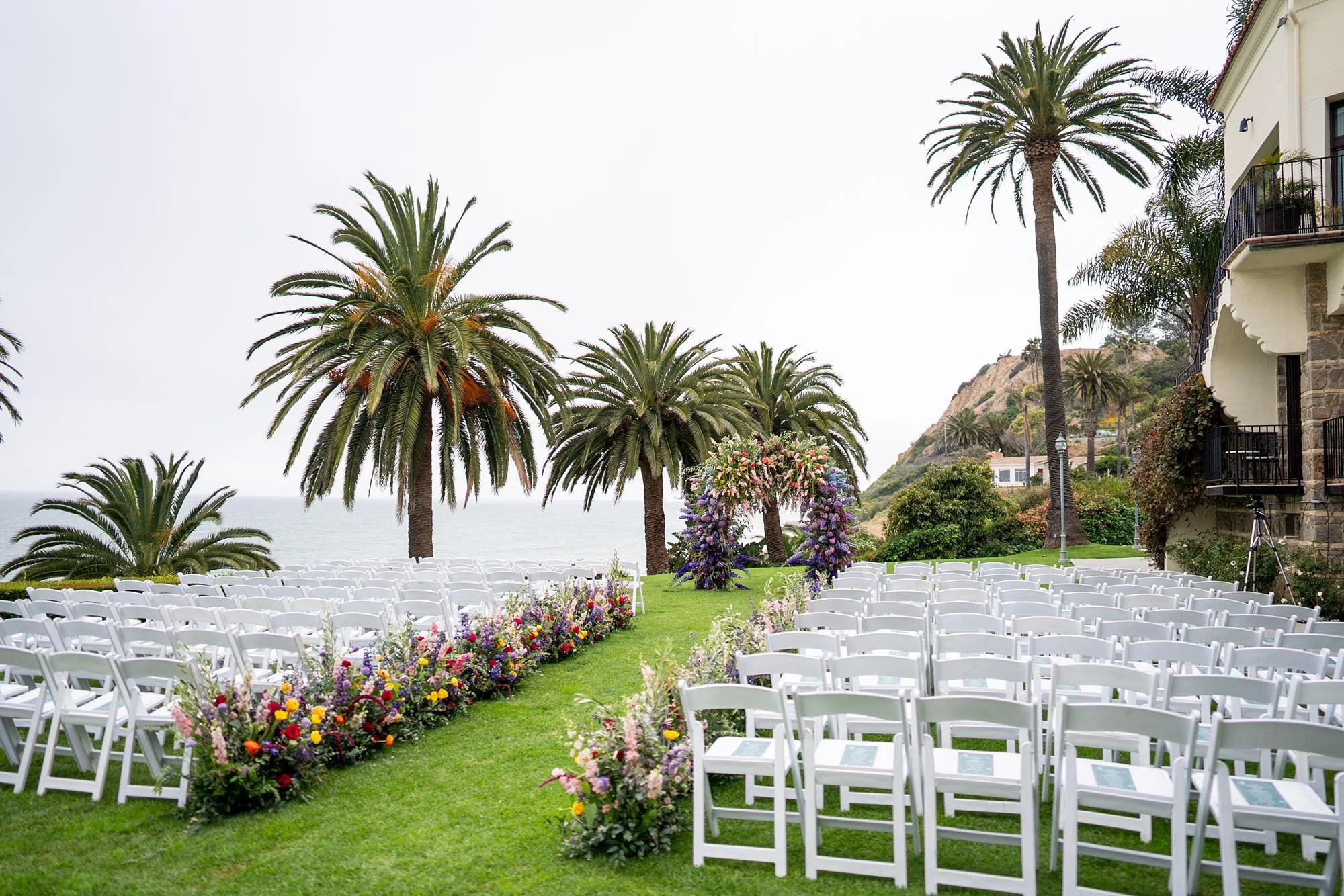 Colorful wild flower aisle and floral arch at an Ocean Lawn wedding ceremony at Bel Air Bay Club