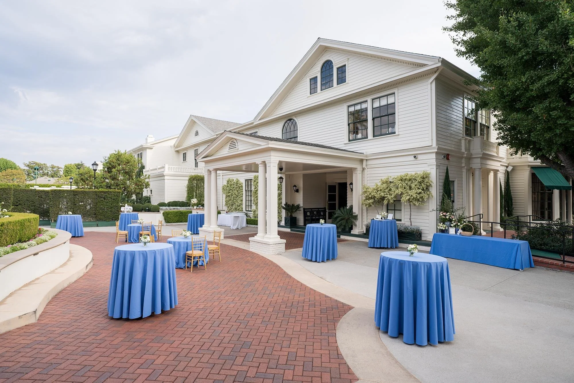 Wedding cocktail hour tables with blue linens and florals at the Valley Hunt Club