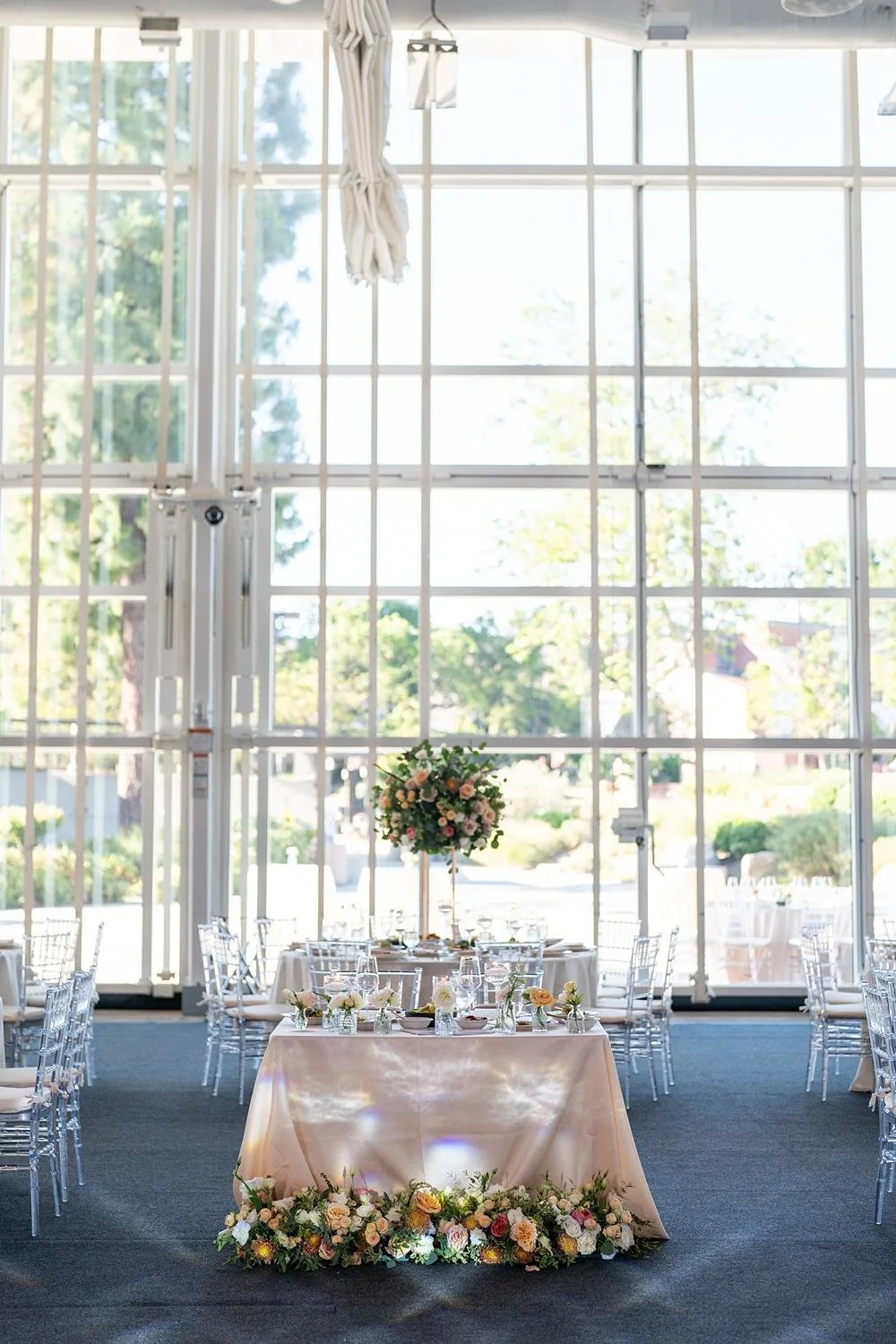 Wedding reception detail of sweetheart table in front of windows at Stephen Wise Temple