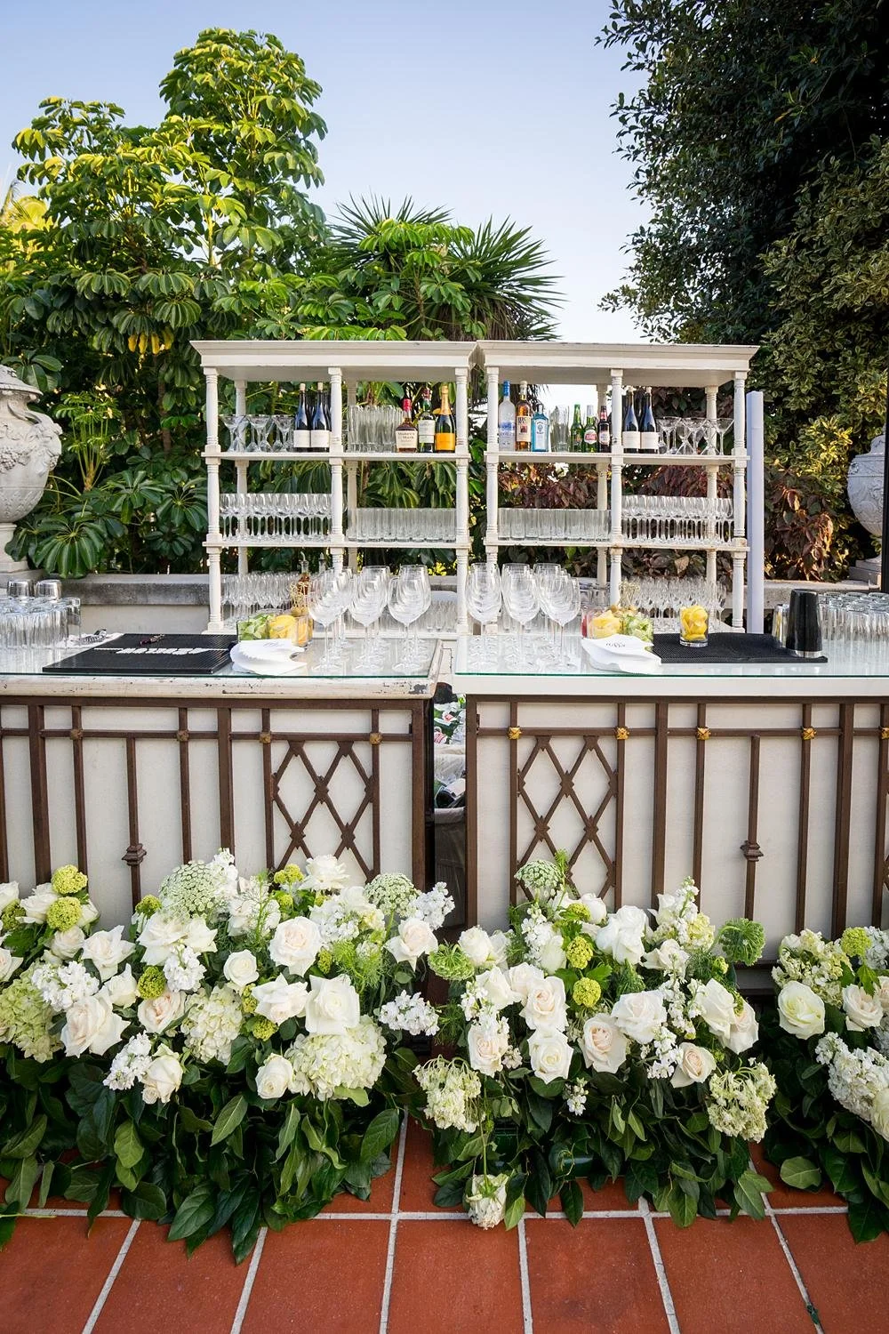 Detail of custom bar between stone urns decorated with florals at South Terrace wedding reception at Huntington Library