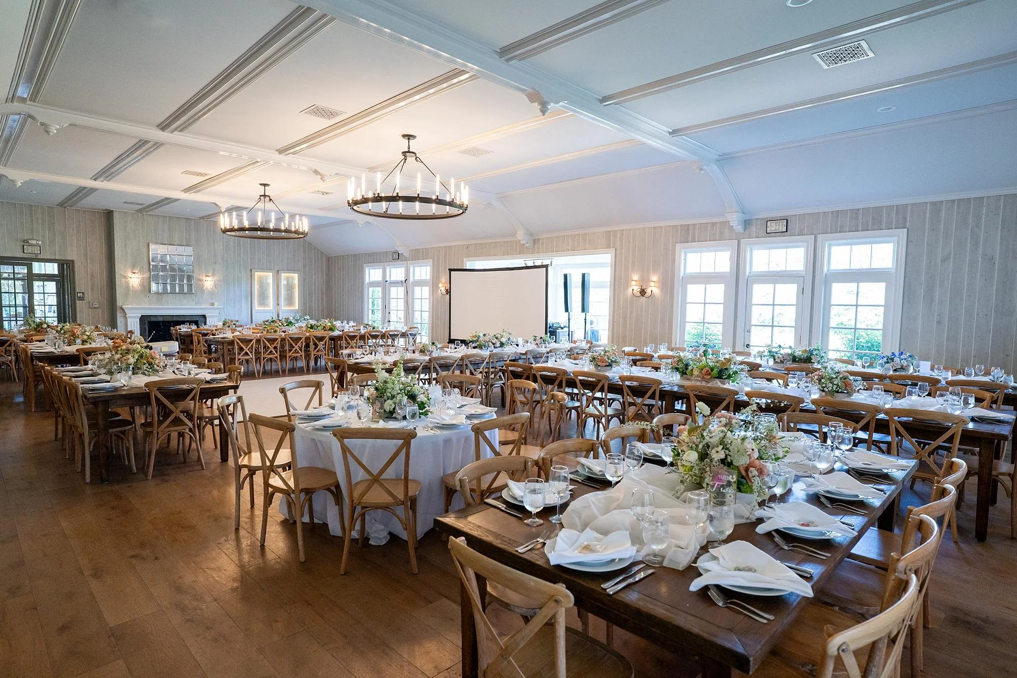 Wedding reception in the Lodge at Malibou Lake Ballroom with white fabric runners and floral centerpieces