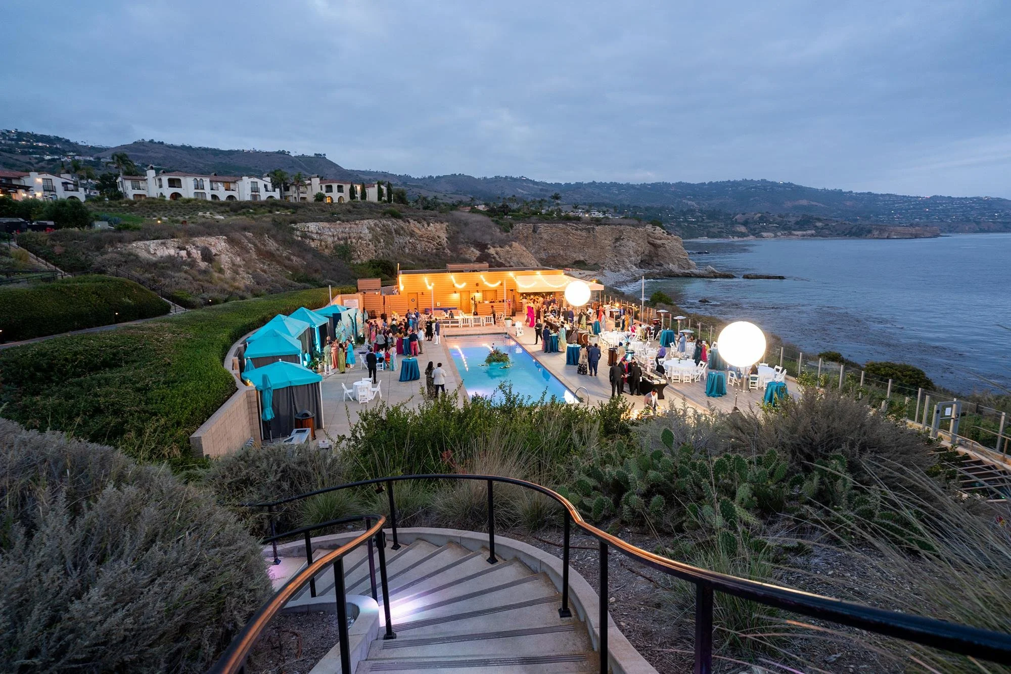 Guests enjoying evening Sangeet at Cielo Pool with coastline and ocean backdrop at Terranea Resort