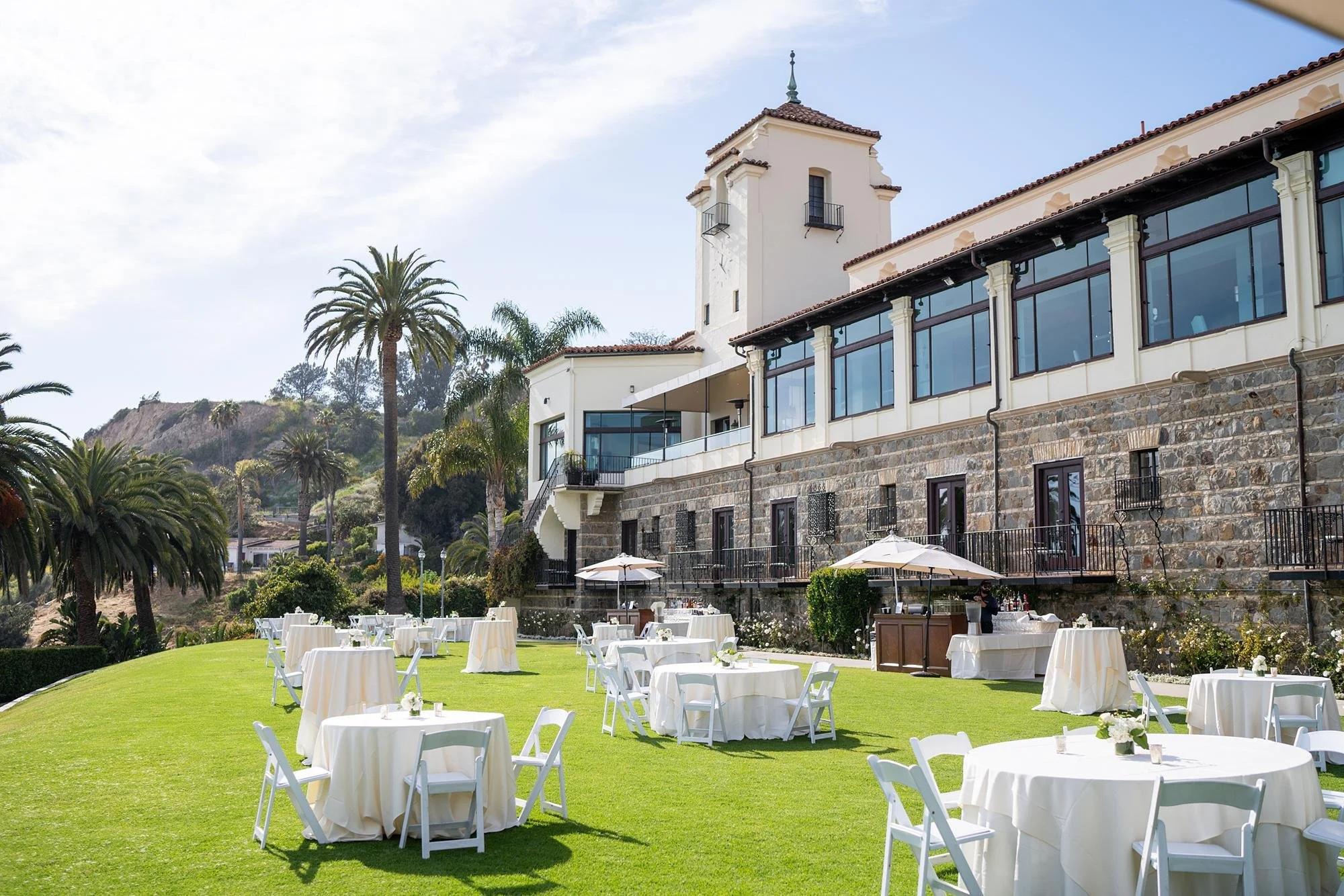 Wide view of wedding cocktail hour on the Ocean Lawn with Bel Air Bay Club backdrop