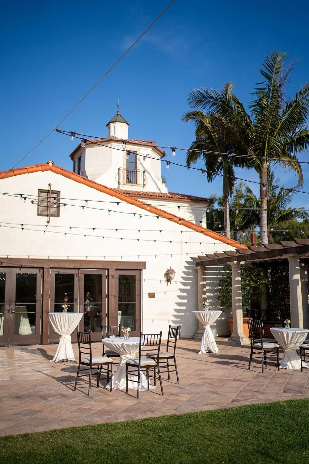 Wedding cocktails on the patio at Palos Verdes Golf Club with tables and clubhouse view
