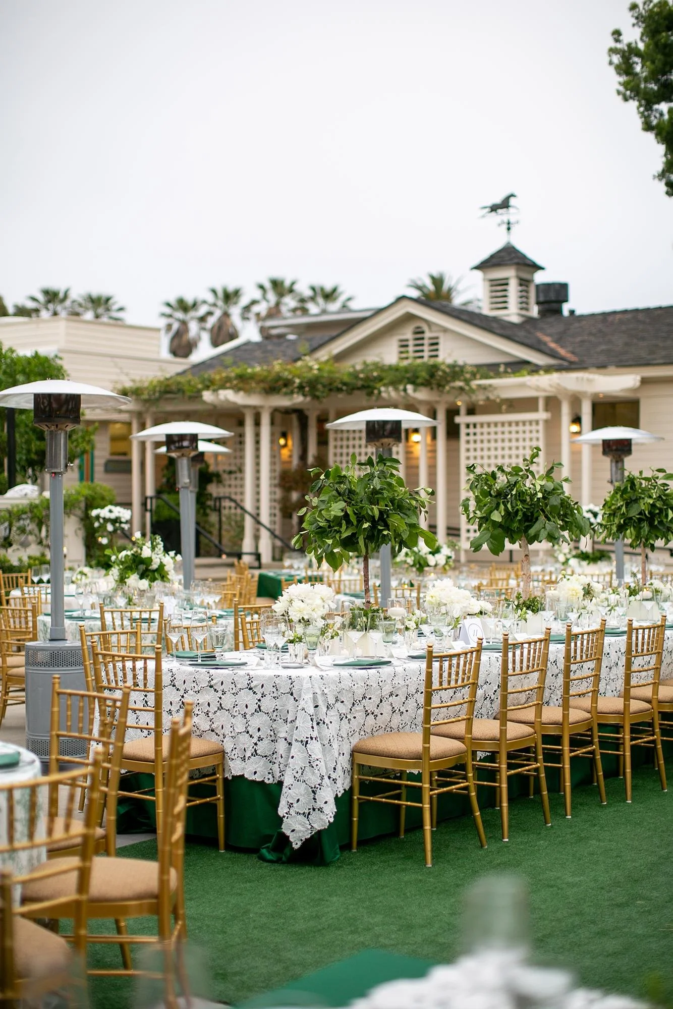 Wedding reception tables with lace linens and greenery garlands on the Back Lawn at the Valley Hunt Club