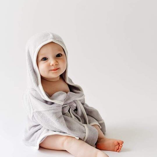 A baby in a bathrobe. 😍 Kyte Baby Bamboo hooded robe (also comes in mommy size)  shown in storm with cloud trim!