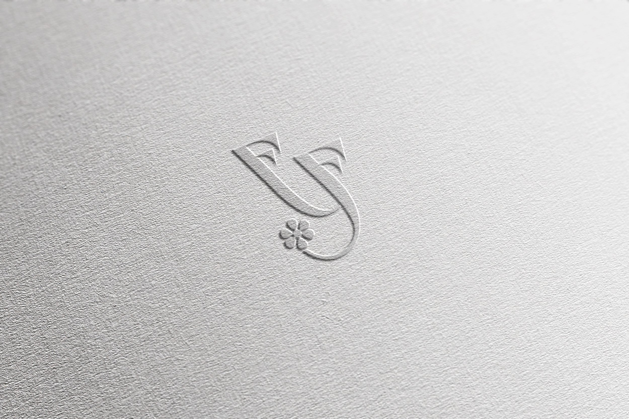 Design del logo Fantasy Fiori versione monogramma su mockup effetto timbro a secco su carta