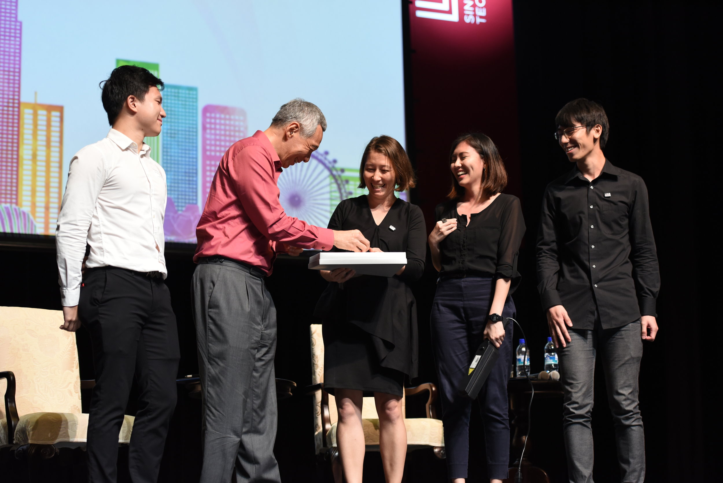  Miho Mazereeuw, Delane Foo Wei En and Kenneth Teo Liguang presenting token to Prime Minister Lee Hsien Loong 
