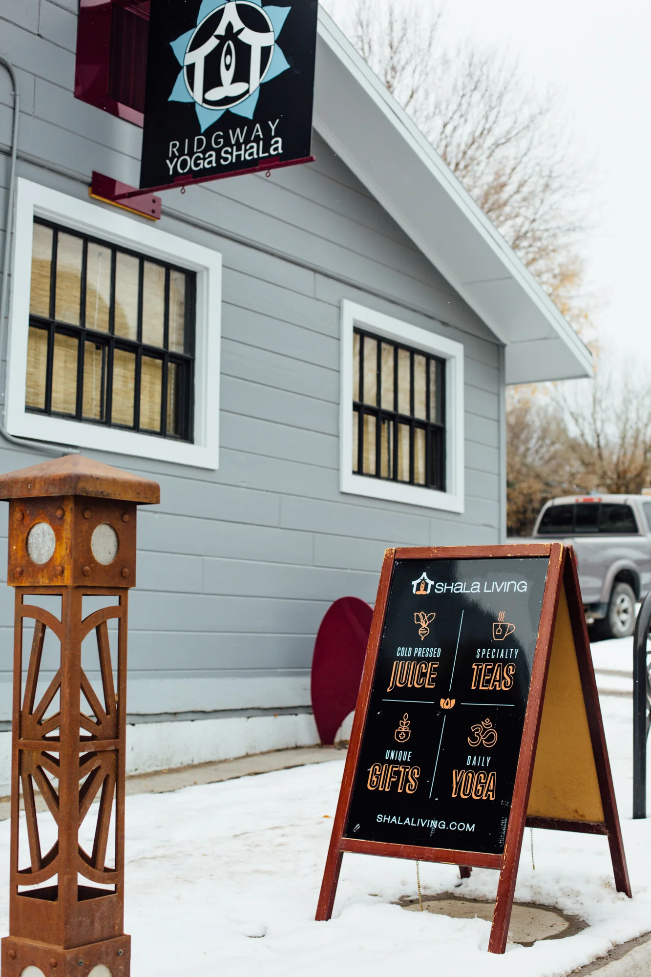 A sandwich board Sitting outside of the Ridgway Yoga Shala with graphics we designed