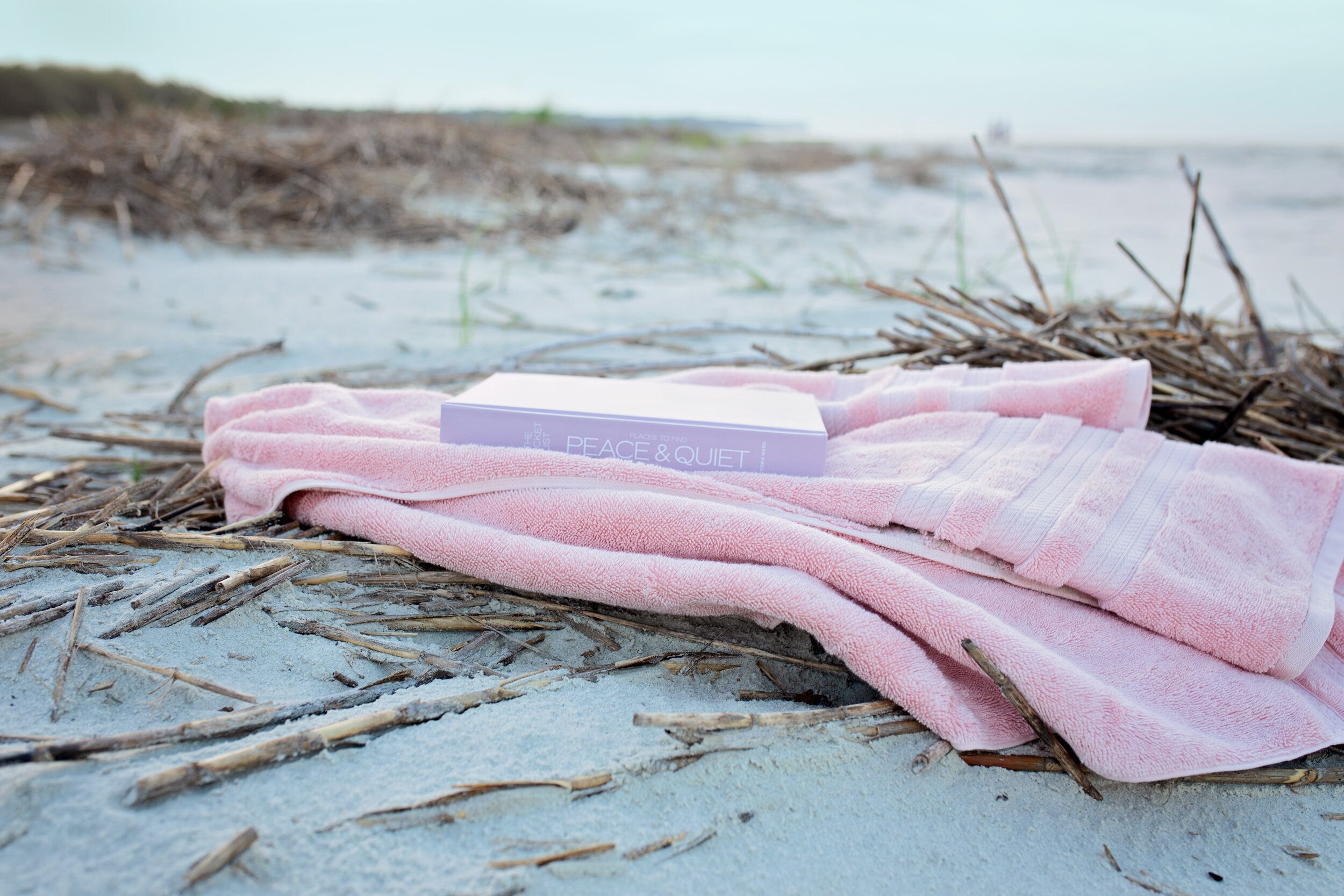 book-on-pink-textile-on-sand-during-day-2997957.jpg