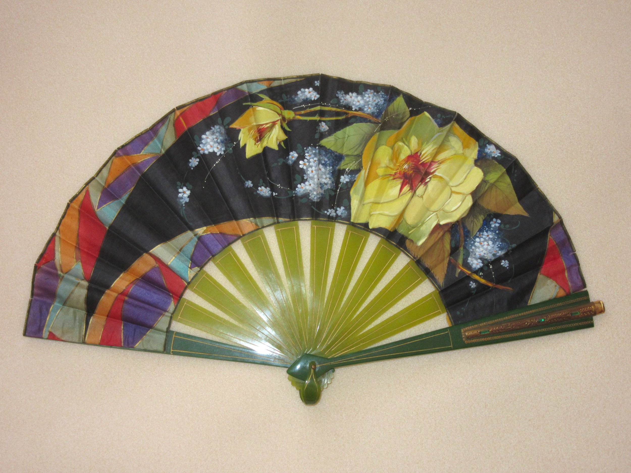 colorful fan with flowers and green sticks 