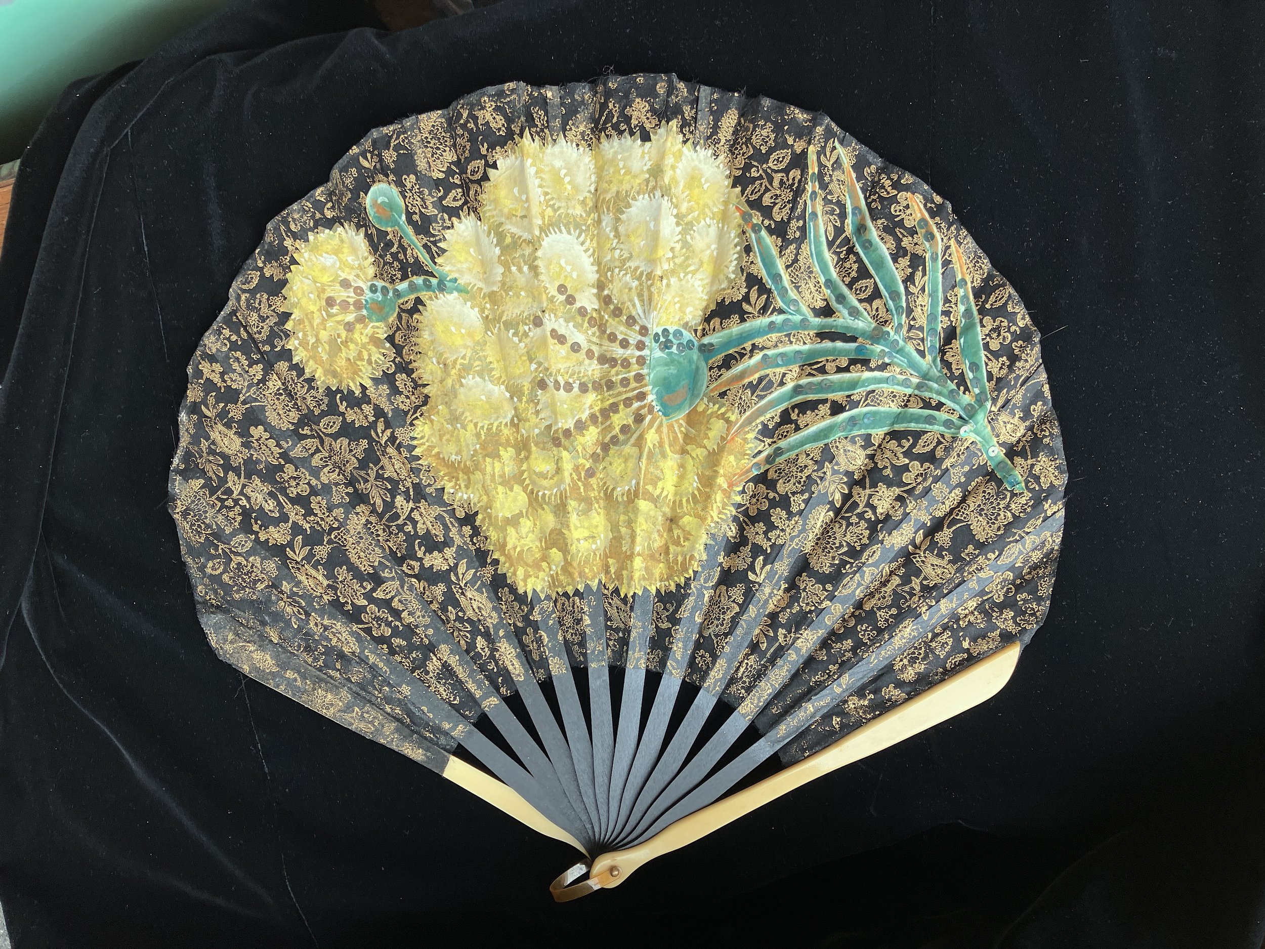 Large Art Deco balloon fan, the wood sticks and galalith guards topped by a fabric leaf printed with a semi of flowers and painted with a beautiful yellow carnation embroidered with sequins 