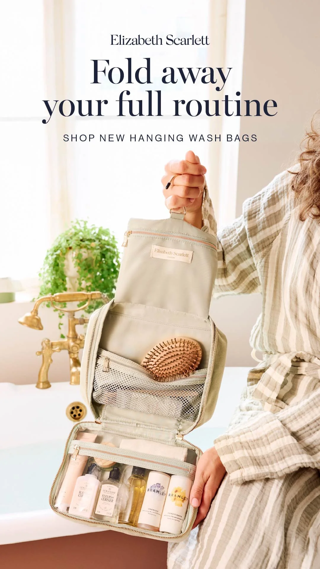 A woman showing an organised toiletry bag with skincare and haircare products inside, in a bathroom with a gold faucet and a potted plant on the windowsill.