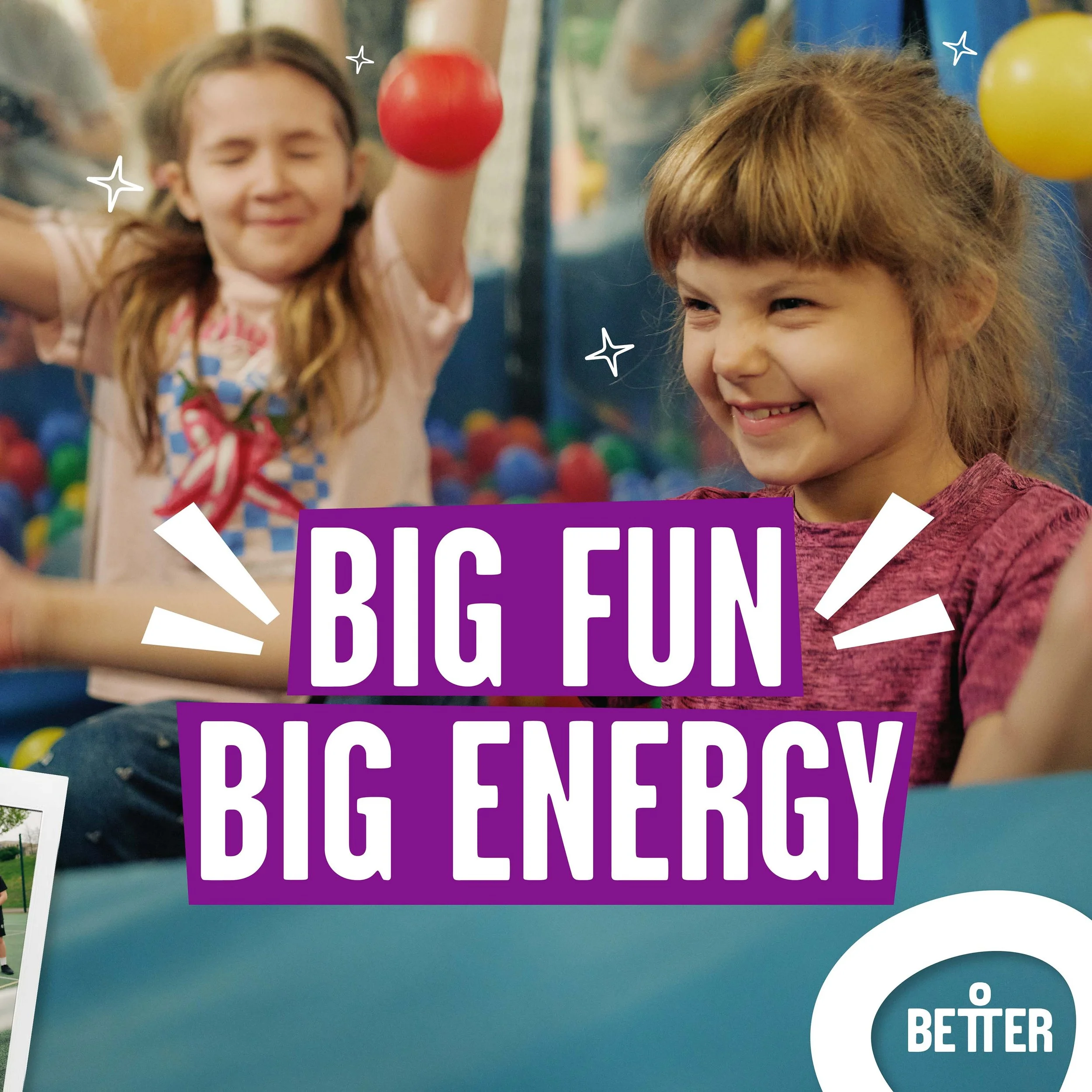 Children playing in an indoor playground with colorful balls, one girl is smiling and another girl with closed eyes is holding a red ball.