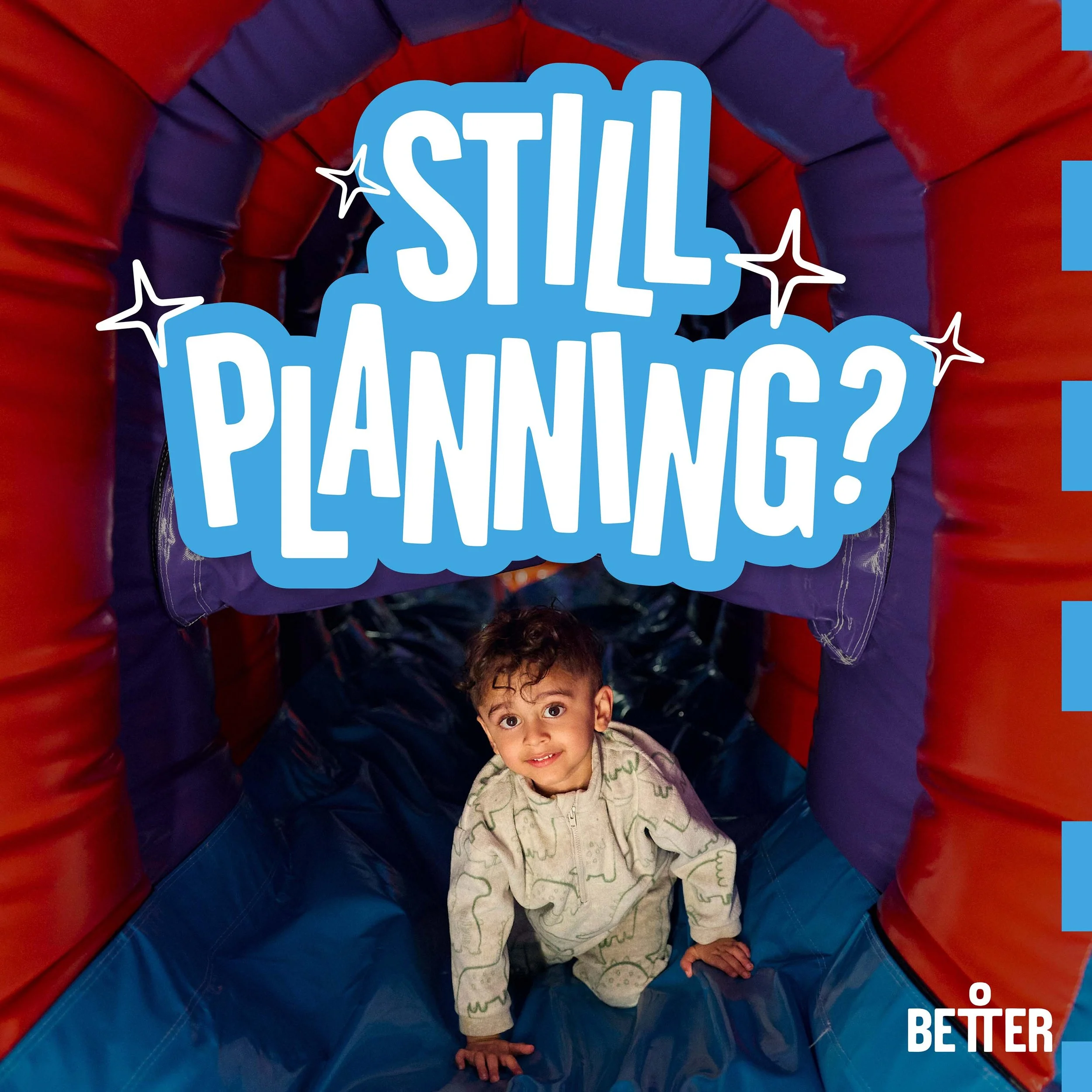 Young child in pajamas crawling inside a colorful inflatable bounce house or obstacle course with red and blue sections.
