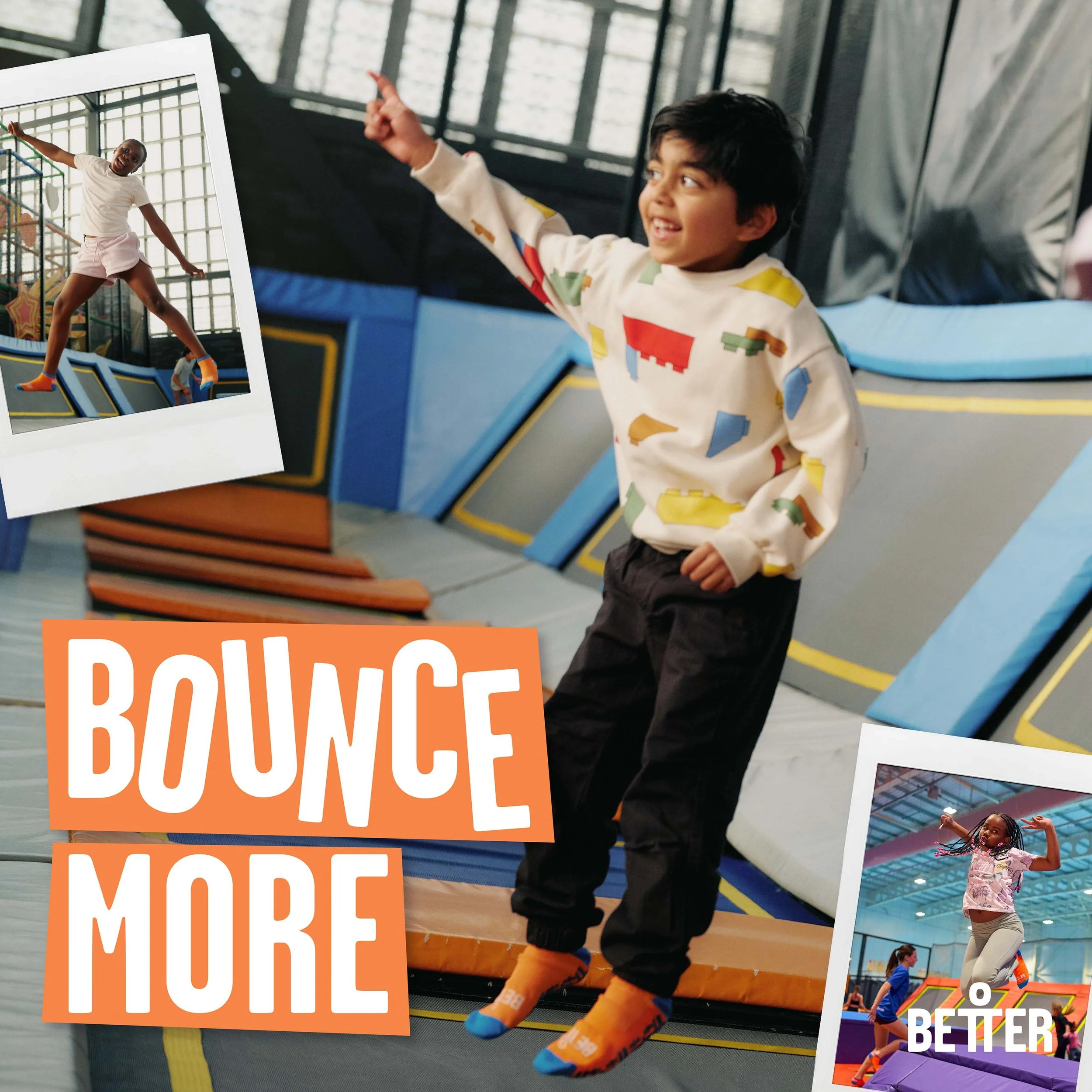 A young boy with dark hair smiling, wearing a colorful shirt, black shorts, orange socks, and blue shoes, standing next to a children’s playground surrounded by posters with images of children playing indoor and outdoor activities.