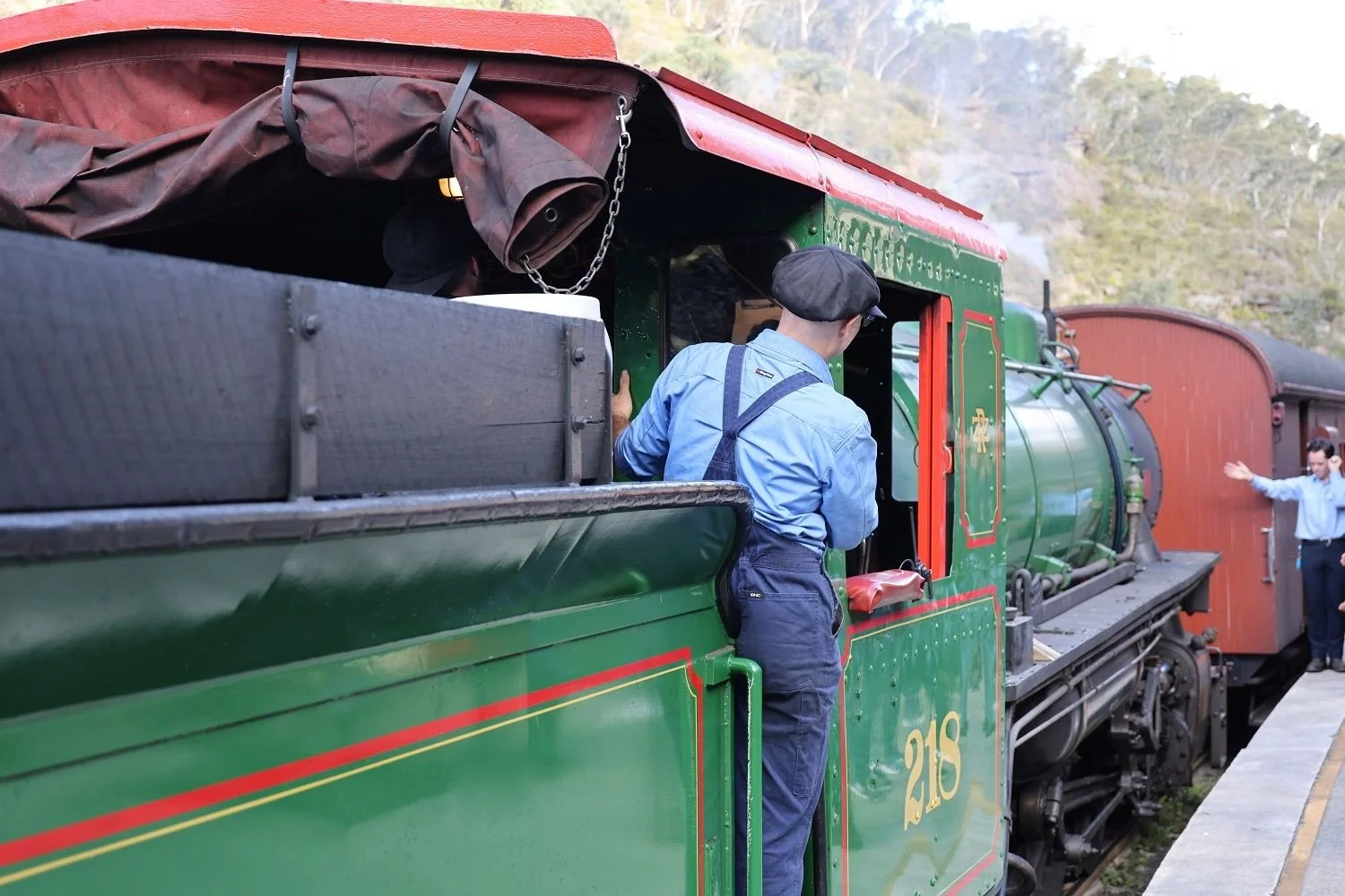 Volunteer driver in period uniform beside steam locomotive 218, Zig Zag Railway