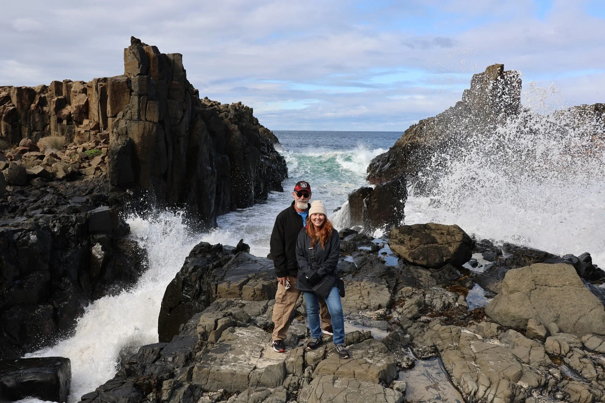 Guests at Bombo Headland Quarry with waves crashing against the basalt columns, Kiama South Coast tour