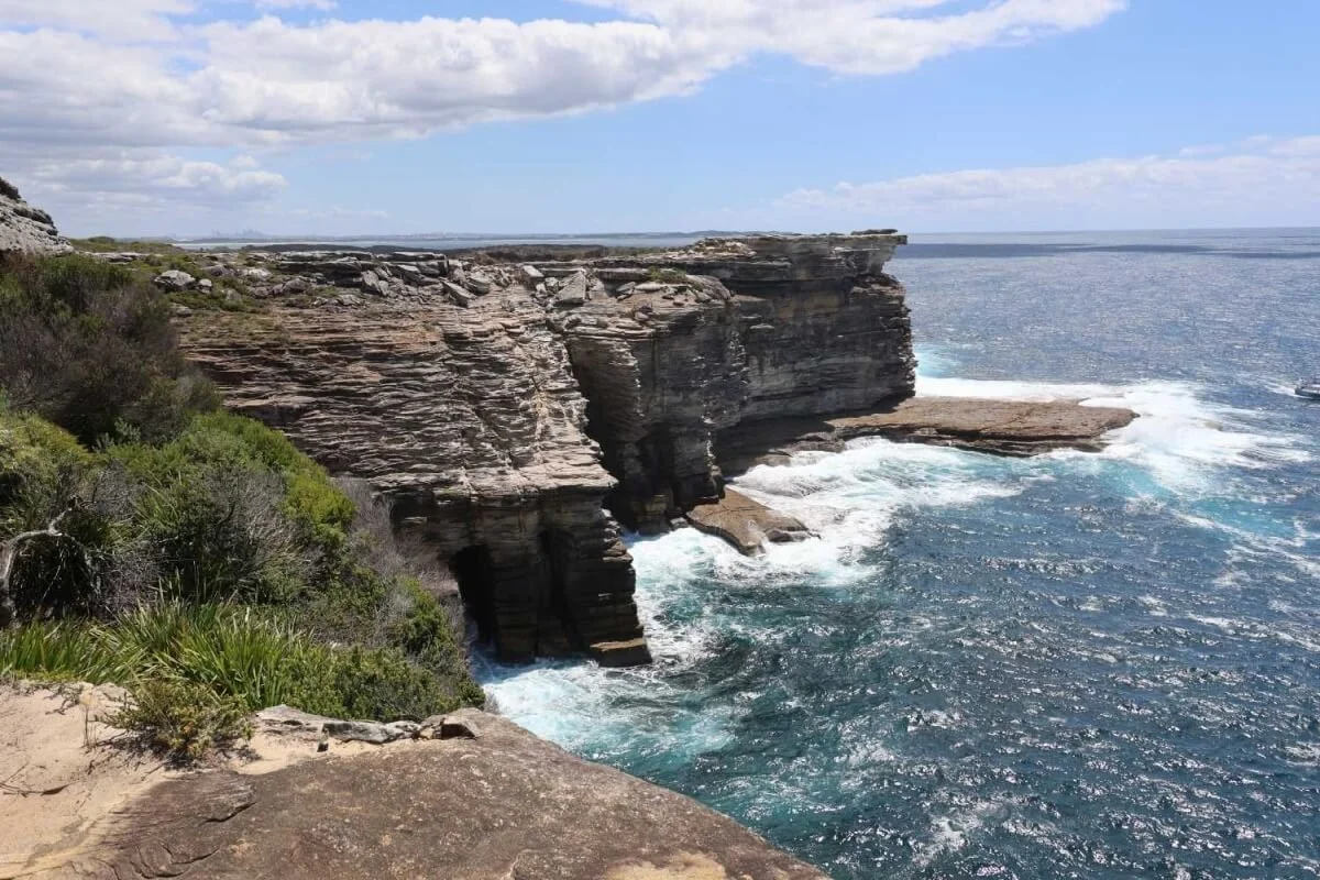 Layered sandstone headland on the Marley track, Royal National Park, with Sydney visible on the horizon