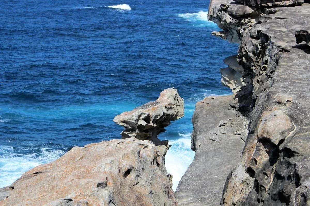 Weathered sandstone formation overhanging the Pacific Ocean on the Wedding Cake Rock walk, Royal National Park