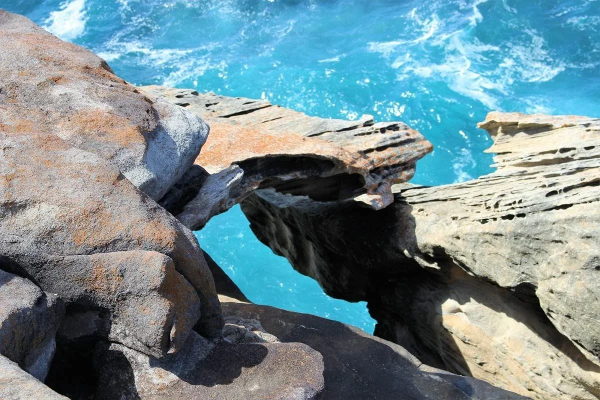 Weathered sandstone formation overhanging the Pacific Ocean on the Wedding Cake Rock walk, Royal National Park