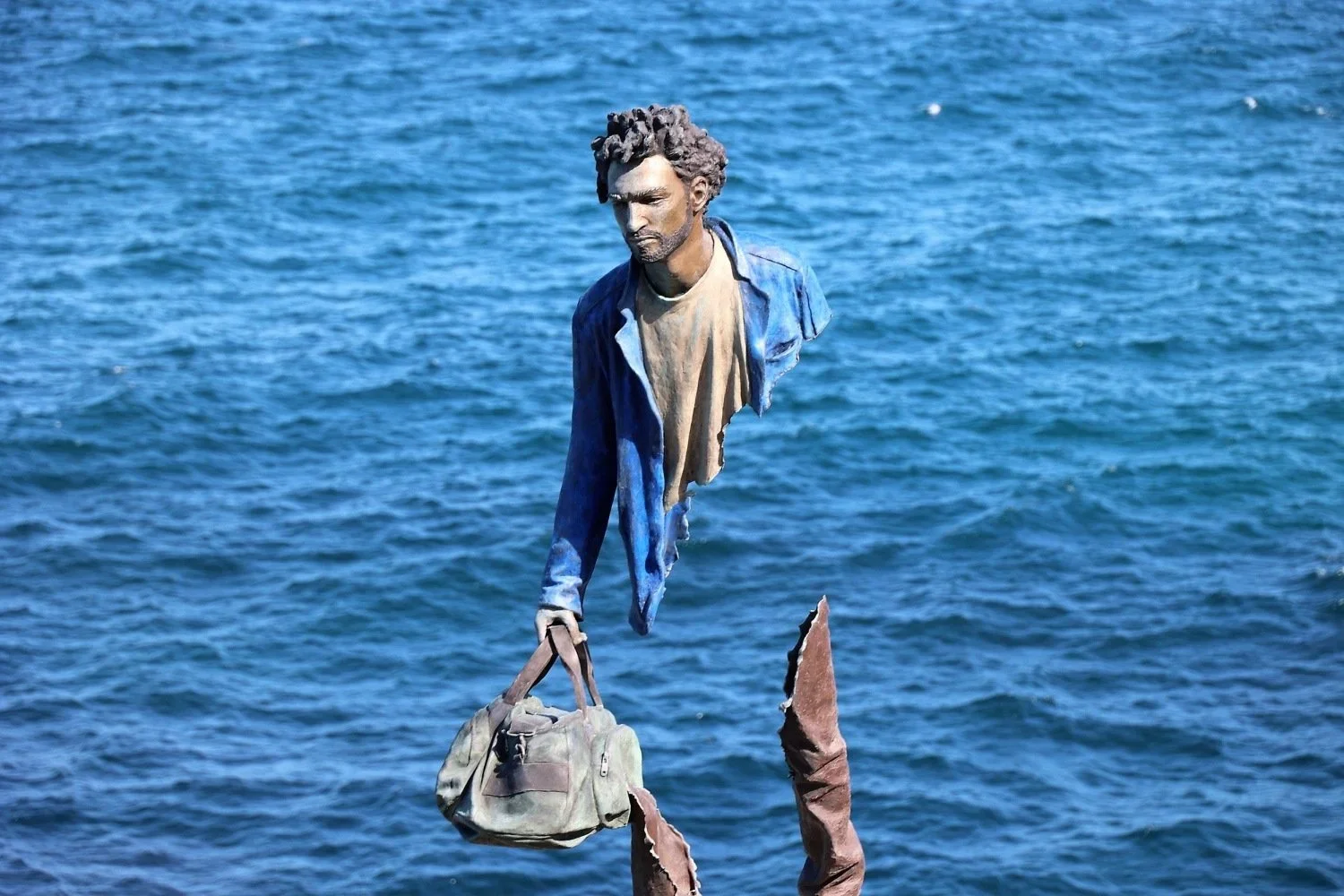 Hyper-realistic figurative sculpture of a man carrying a bag, Sculptures by the Sea Bondi