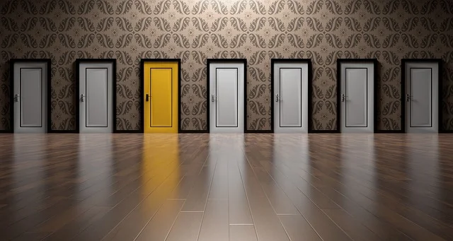 Image Description: Series of white doors with one yellow door.