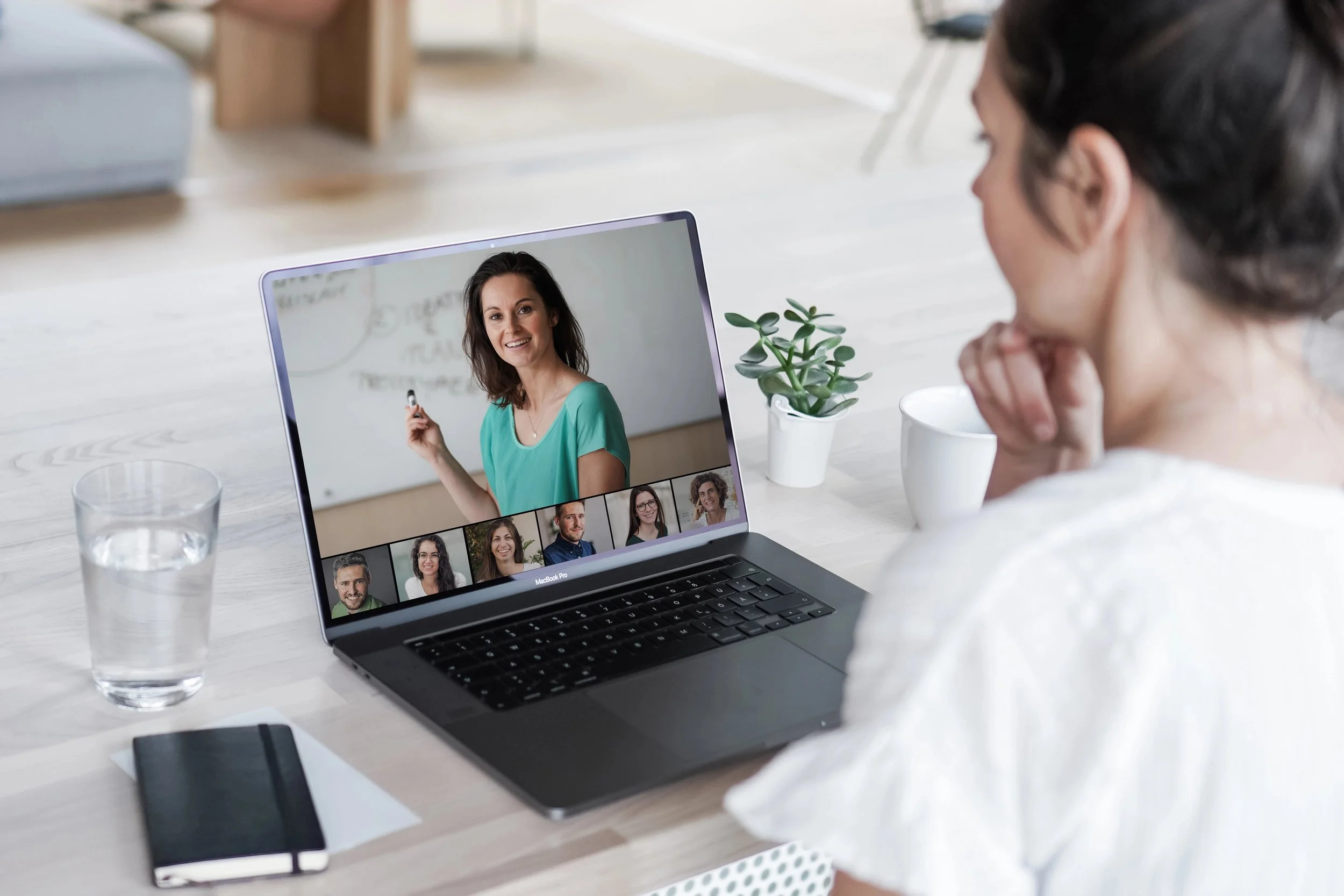 Remote online working woman sitting on a work desk with laptop in in her home office joining an online meeting or watching video conference or webinar presentation