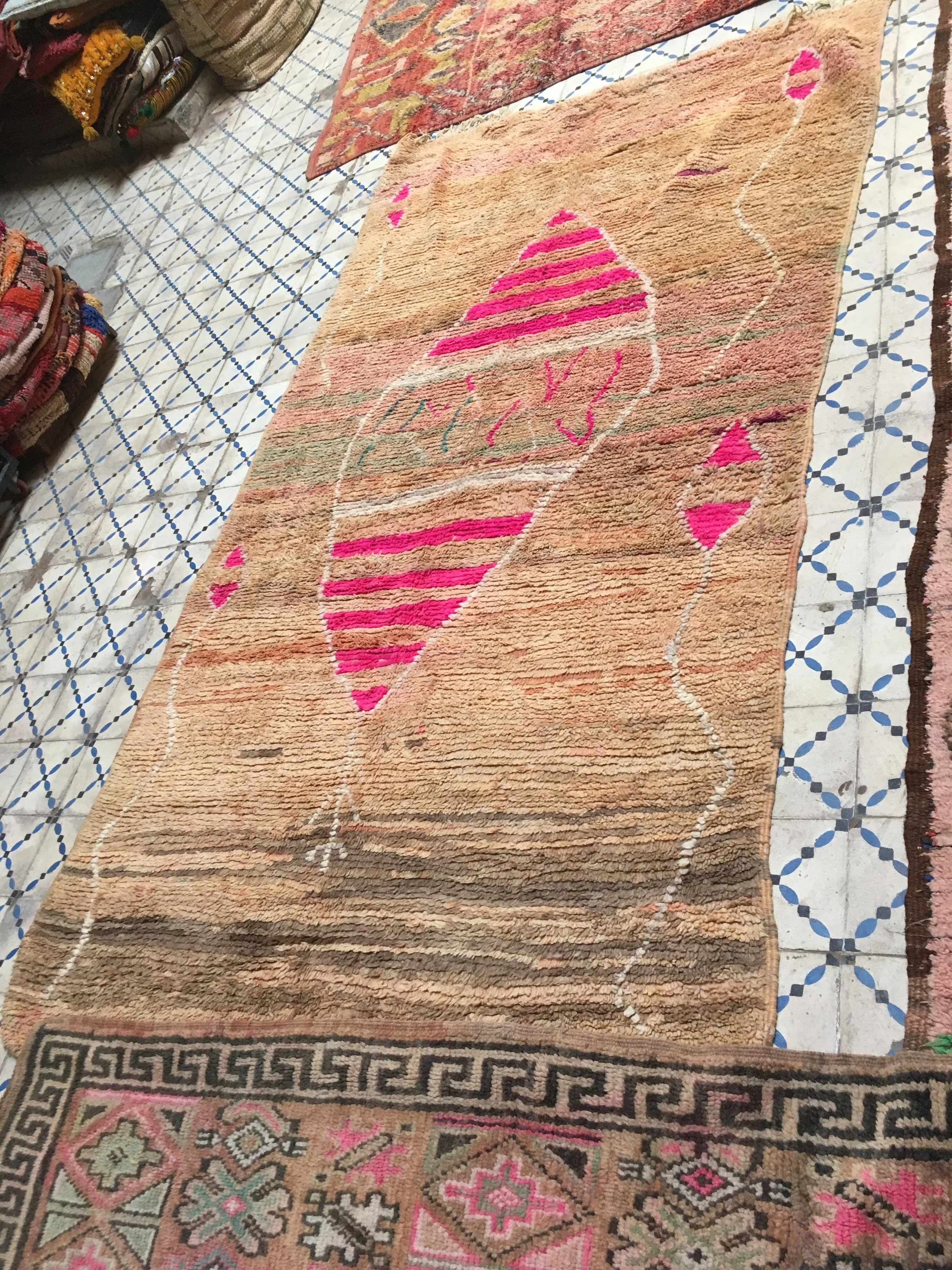 The centre Diamond form symbolised a vagina, with small blue and pink lines/threads within. Blue for a boy, pink for a girl. Four spermatozoids were symbolised at both sides of the rug. But why were they all pink? And why this bright pink? What was this woman telling us? The central area in the carpet was knotted in soft hues of blue and pink…The beginning of the loom was dark, almost dirty… Dark colours symbolise sadness and grief. What happened in her life? The bright pink may symbolise health and fertility, or it might as well stand for a deep wish for a daughter?! One of these carpets that keep on triggering me. The story, however, will always remain but a guess…