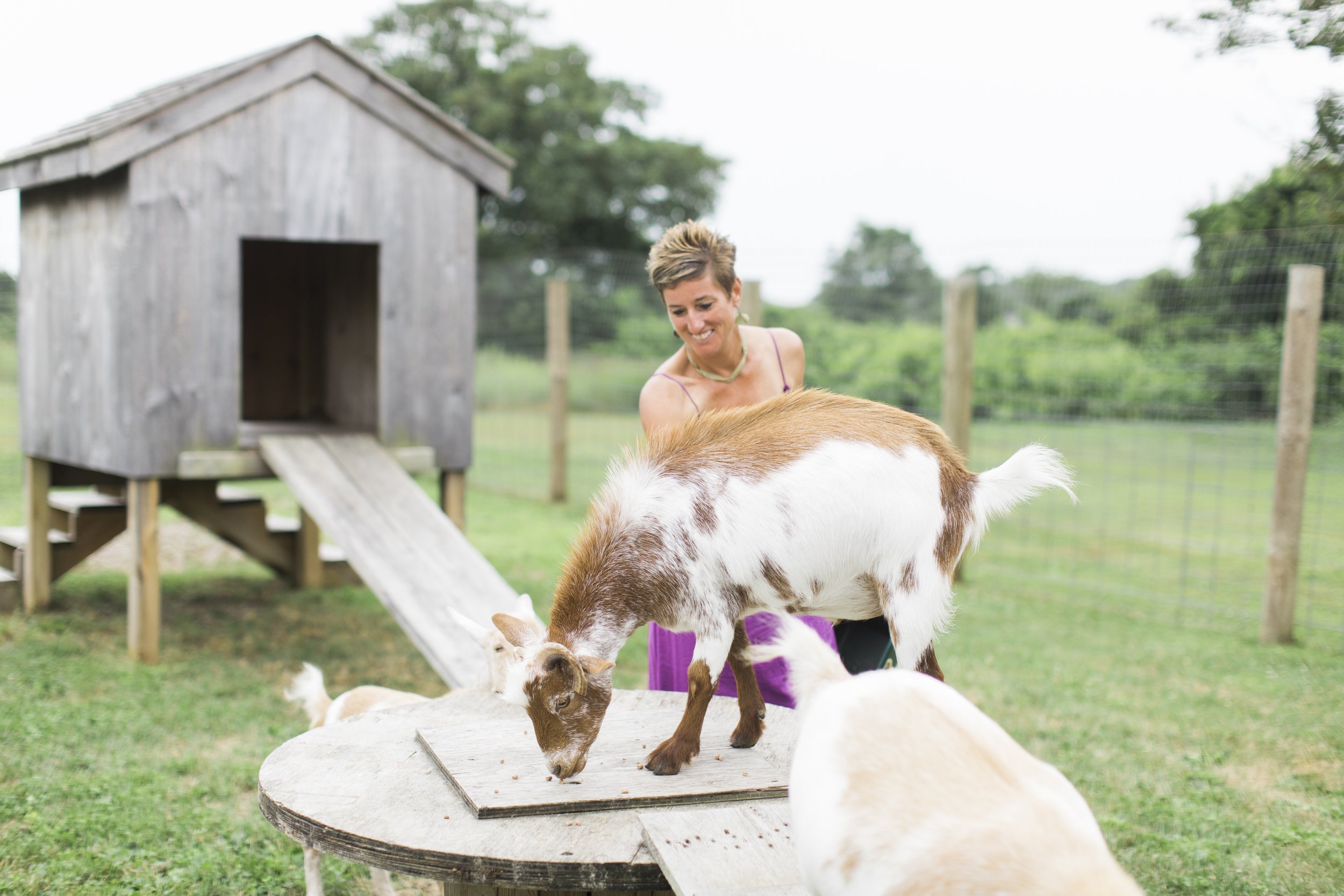 Sue Champagne smiling with her pet goats
