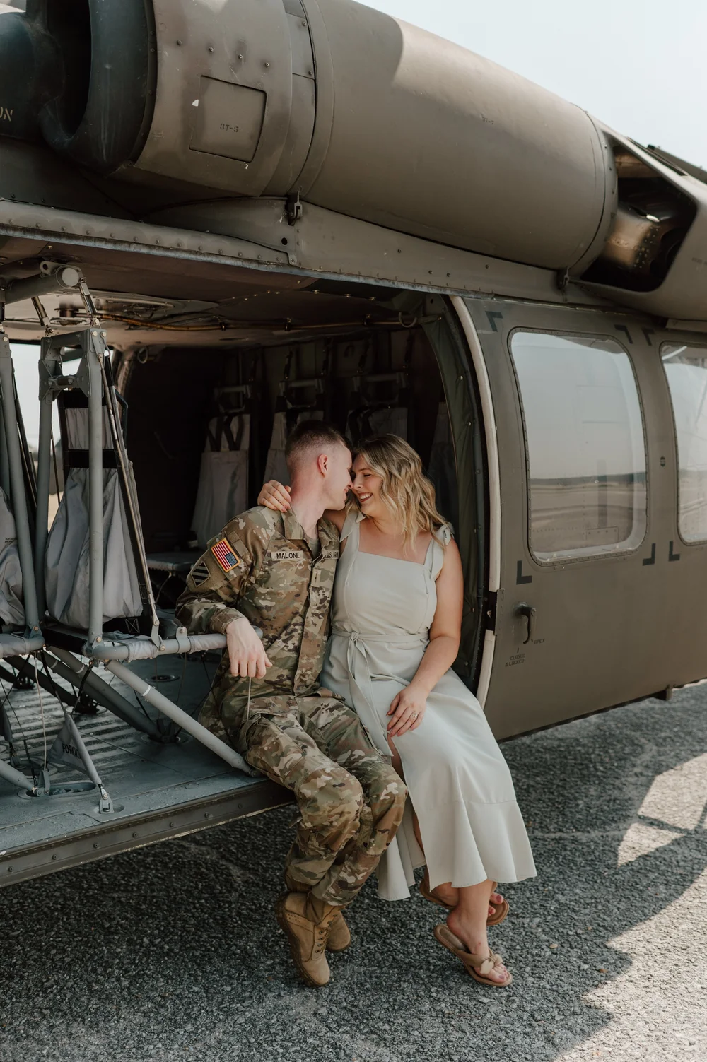  A happy couple snuggle on the edge of a helicopter  