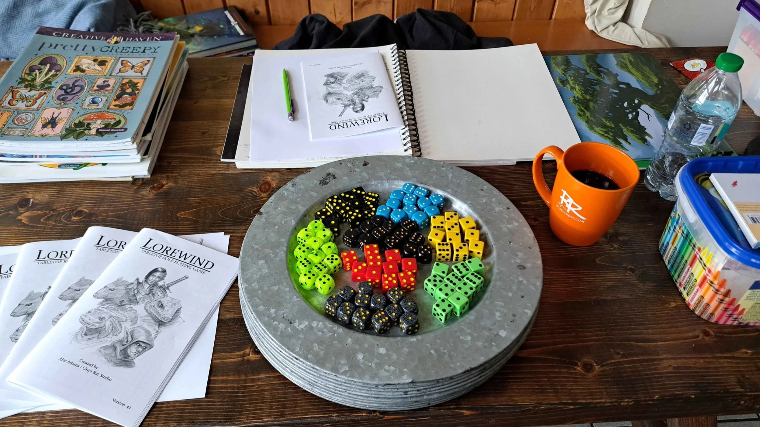 A photo of a table with several sets of d6s, ttrpg manuals and a coffee.