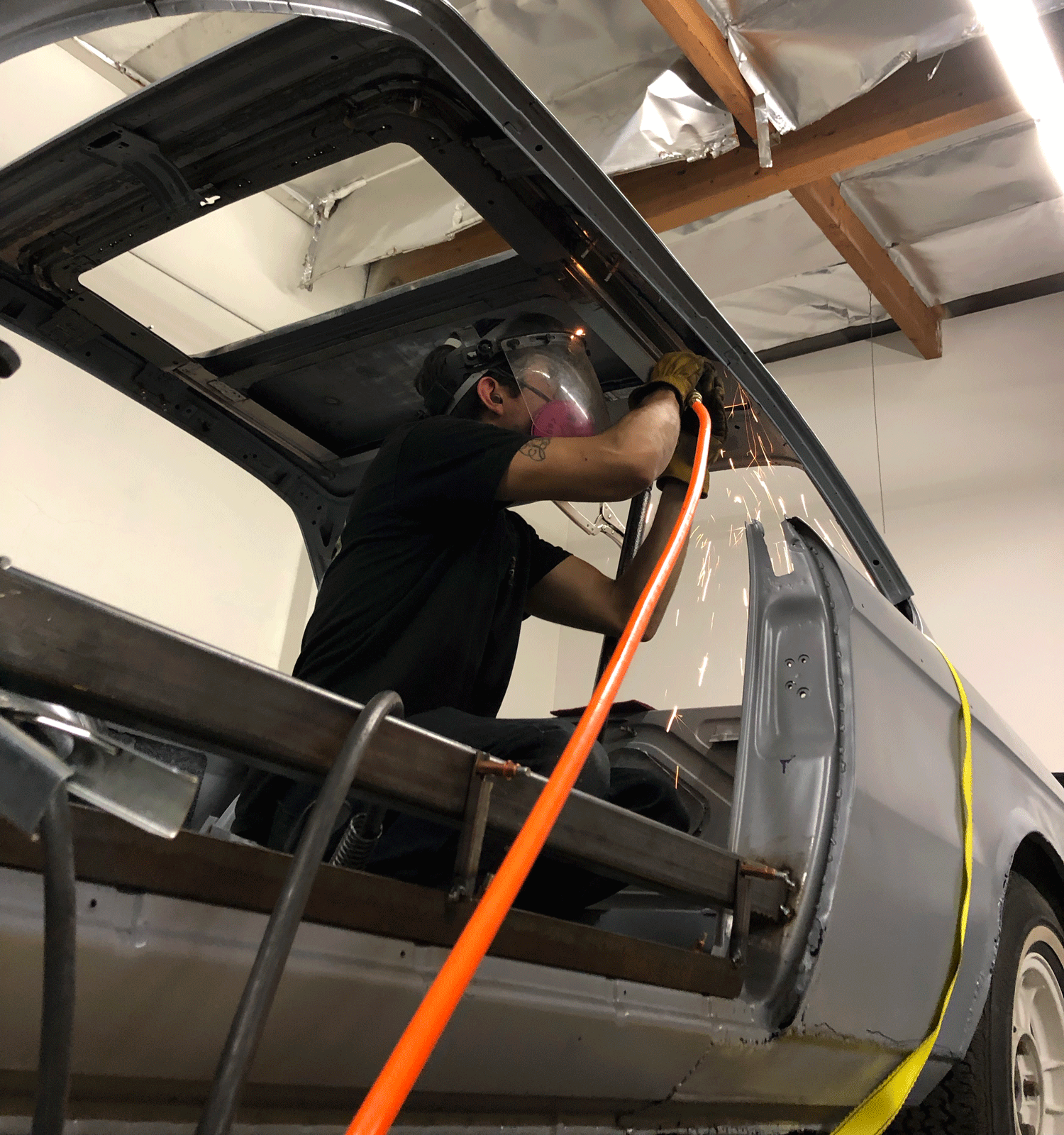 Installing the frame back into the coupe. Tyler loves crawling around grinding things in the car.