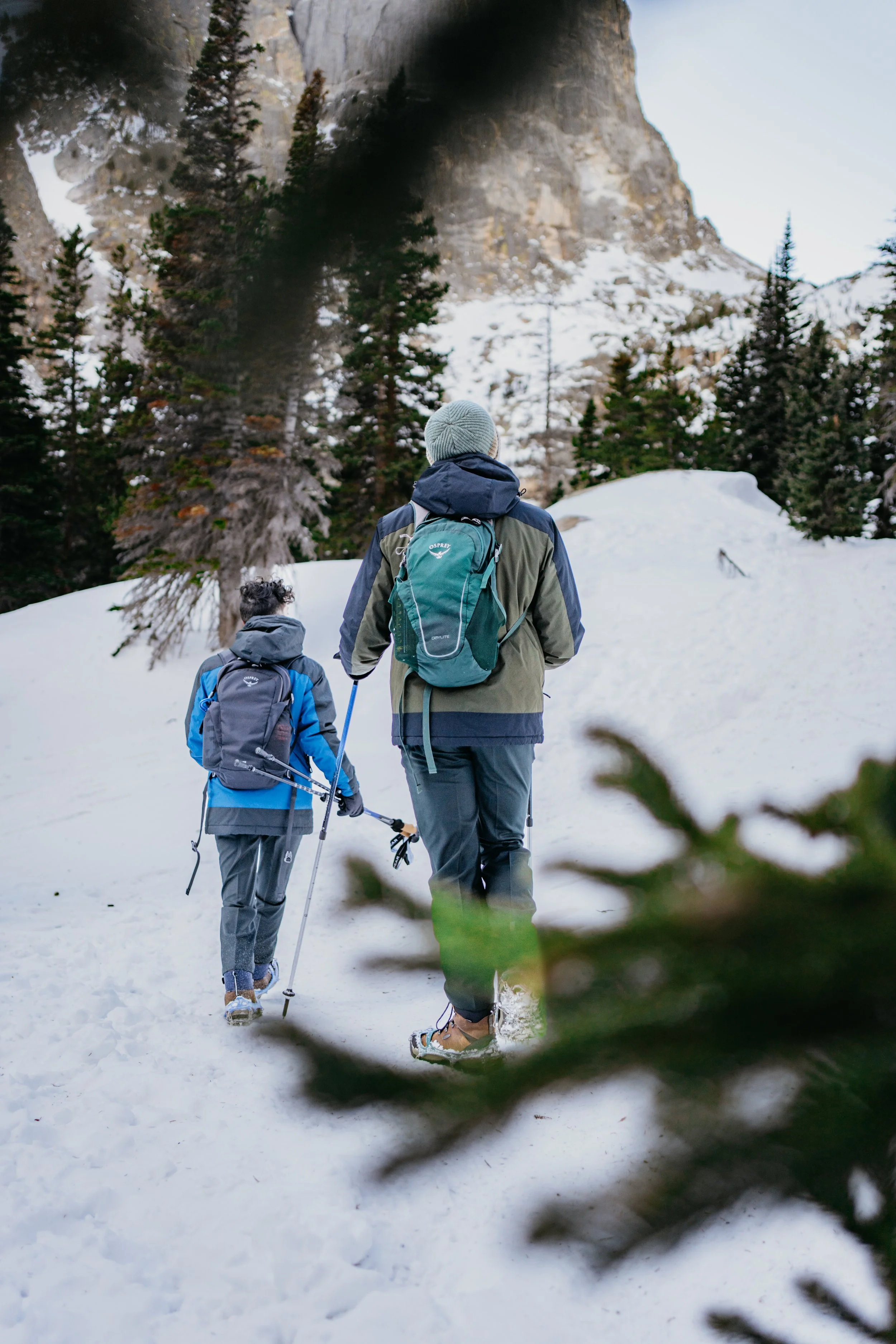Two people are hiking in the snow in rocky mountain national park