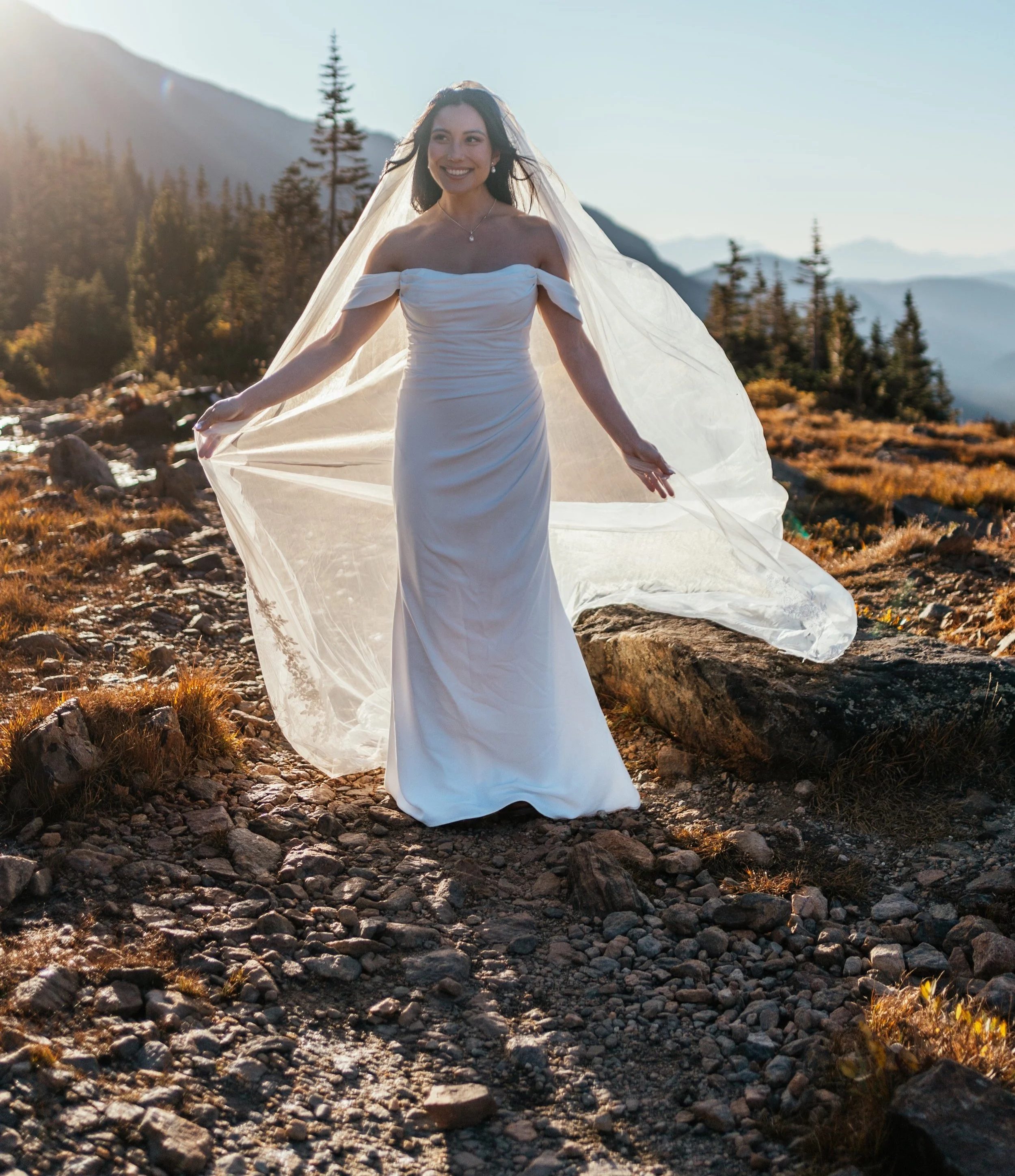 Bride walking outdoors while lifting her veil