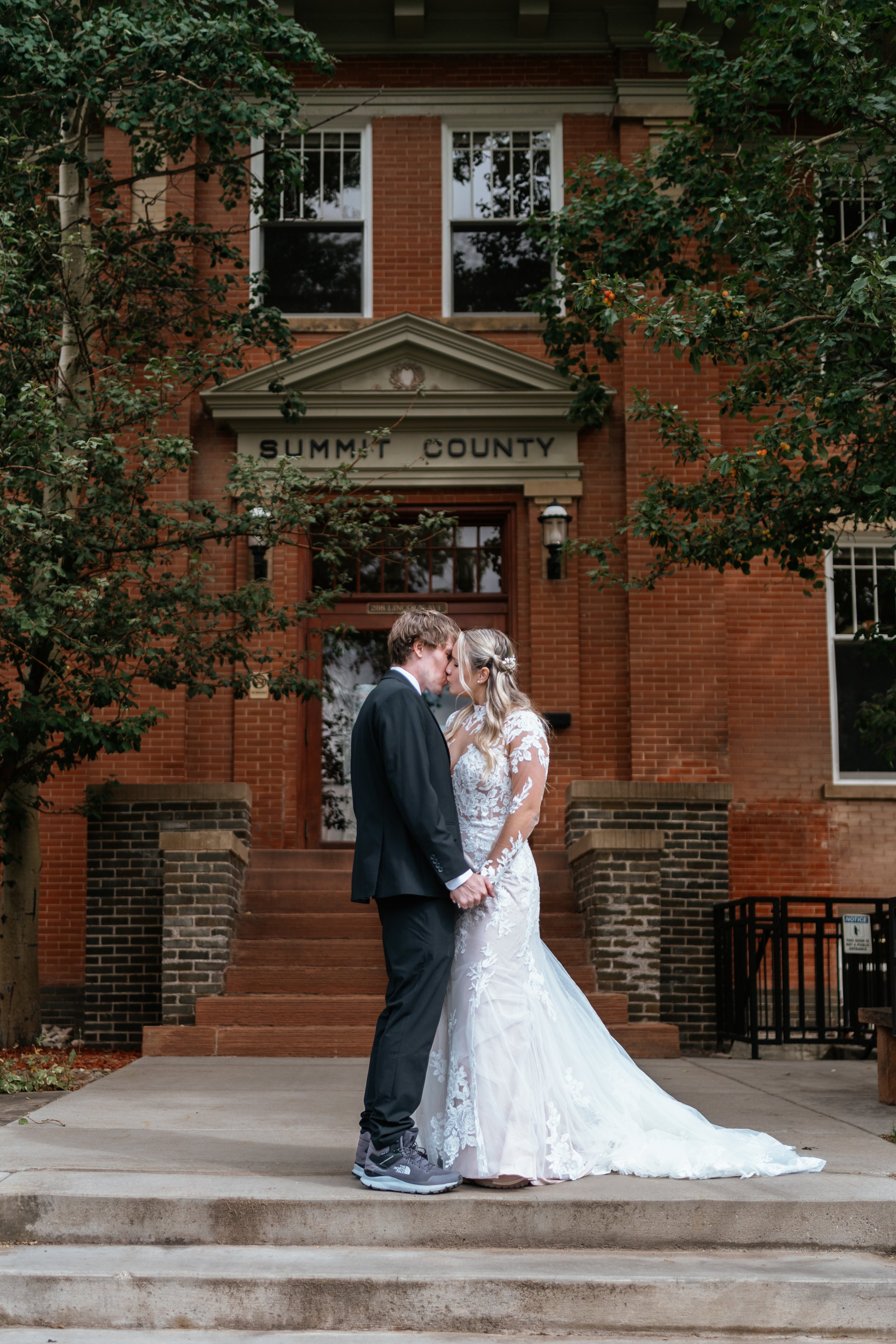 A newly married couple kiss in front of the Summit County office building after dropping off their marriage license.