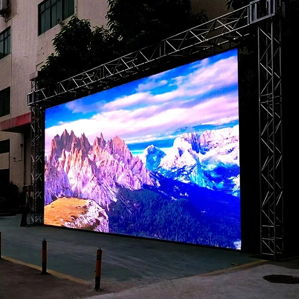 Large outdoor digital screen displaying a mountain landscape scene, set up on a city street.