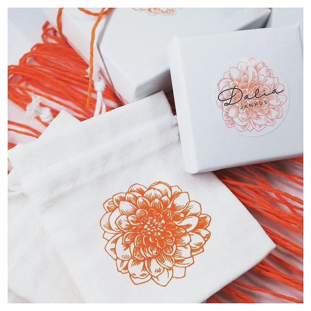 branded packaging of bespoke dust bags and gift boxes with an orange dahlia flower motif