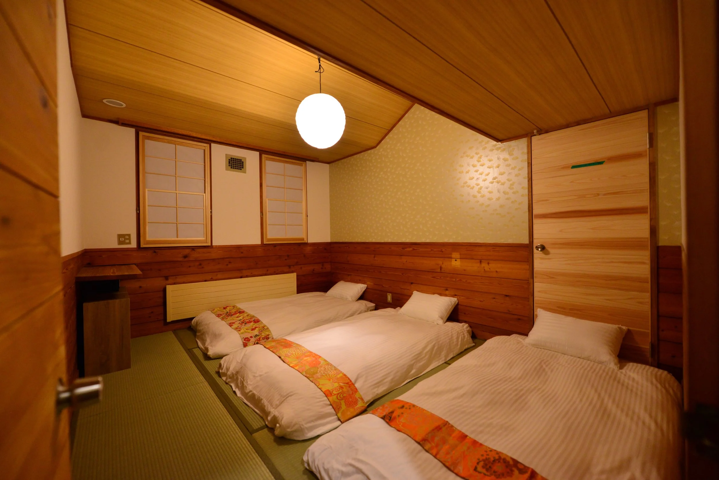 CORNER TATAMI ROOM WITH FUTONS Room for 4 people. Shared facilities, double-thickness futon beds. Views of Madarao Ski Resort Or The Surrounding Mountains.