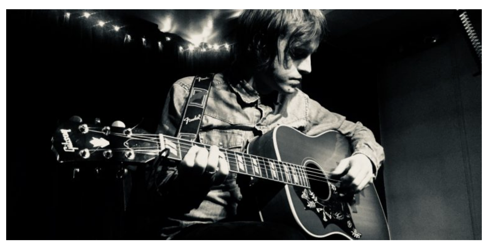 TPLT Latest News: A singer-songwriter likened to John Lennon who gigs worldwide has presented a signed portrait photograph to his former school