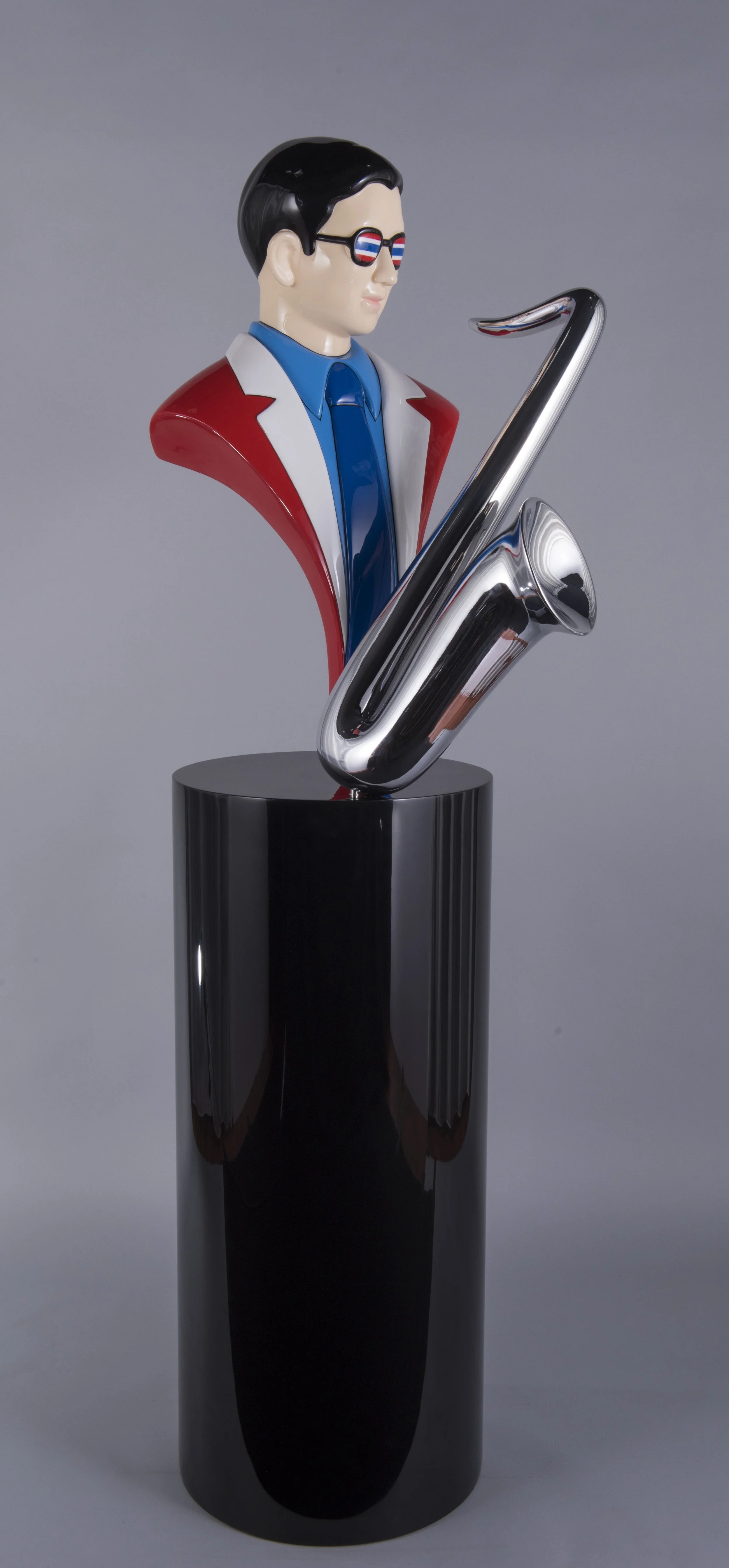 Father Of The Nation, King Rama 9 collection: pop-art bust in Thai flag colours with flag-striped glasses and a chrome saxophone, on a black column