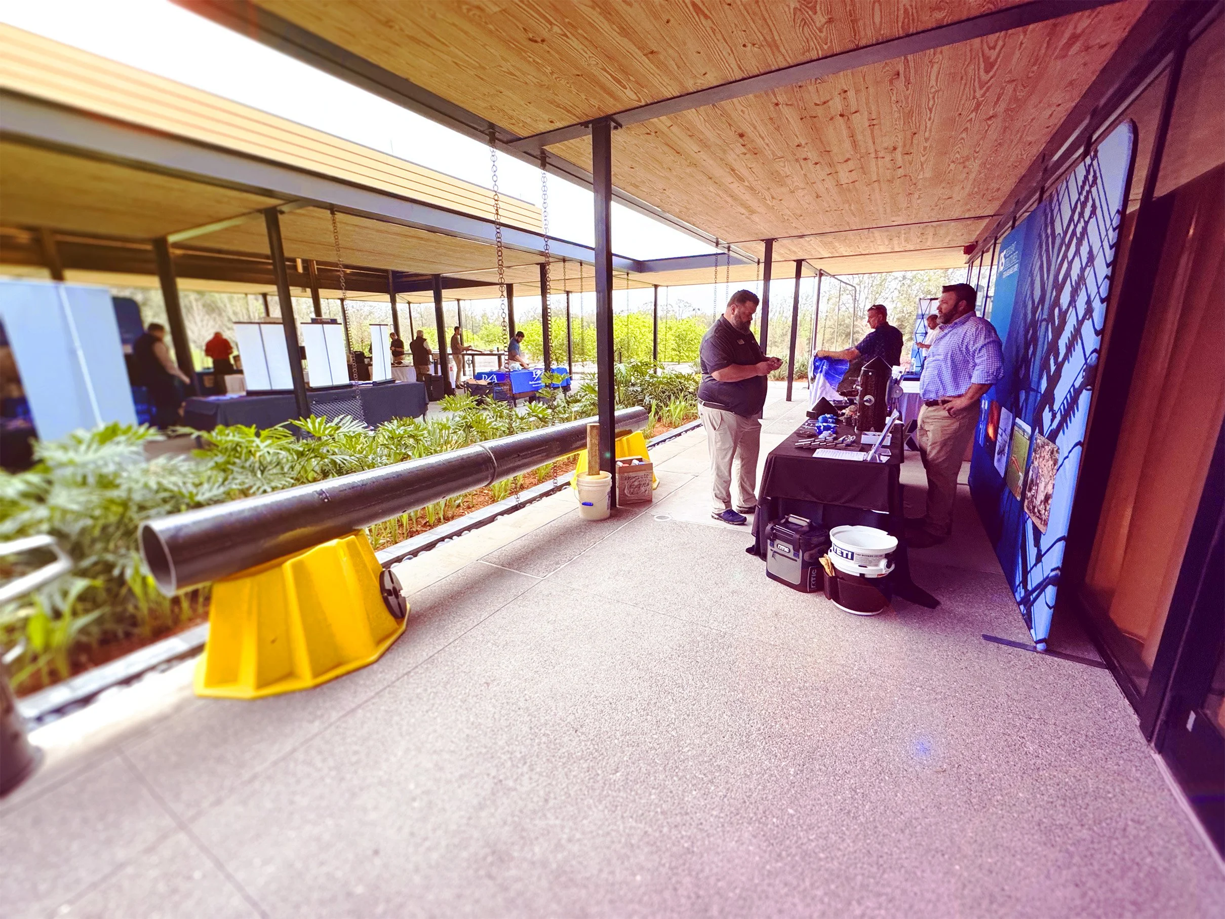 In the early morning hours, USA staff assist Resilient Structures' Brandyn Edwards with setting up a booth at Duke Energy's E-Week 2025
