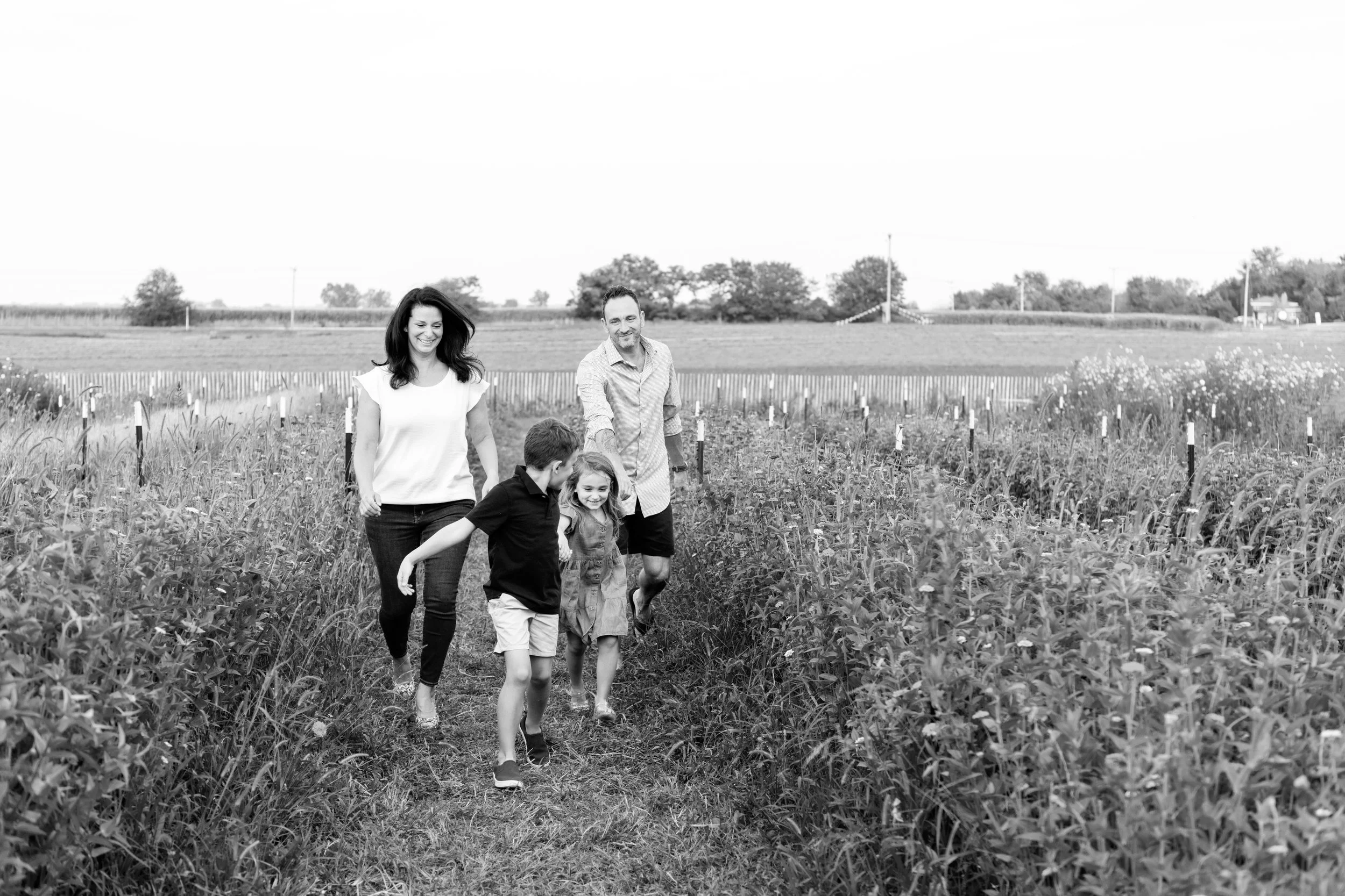 Candid moments of family photo session running in field