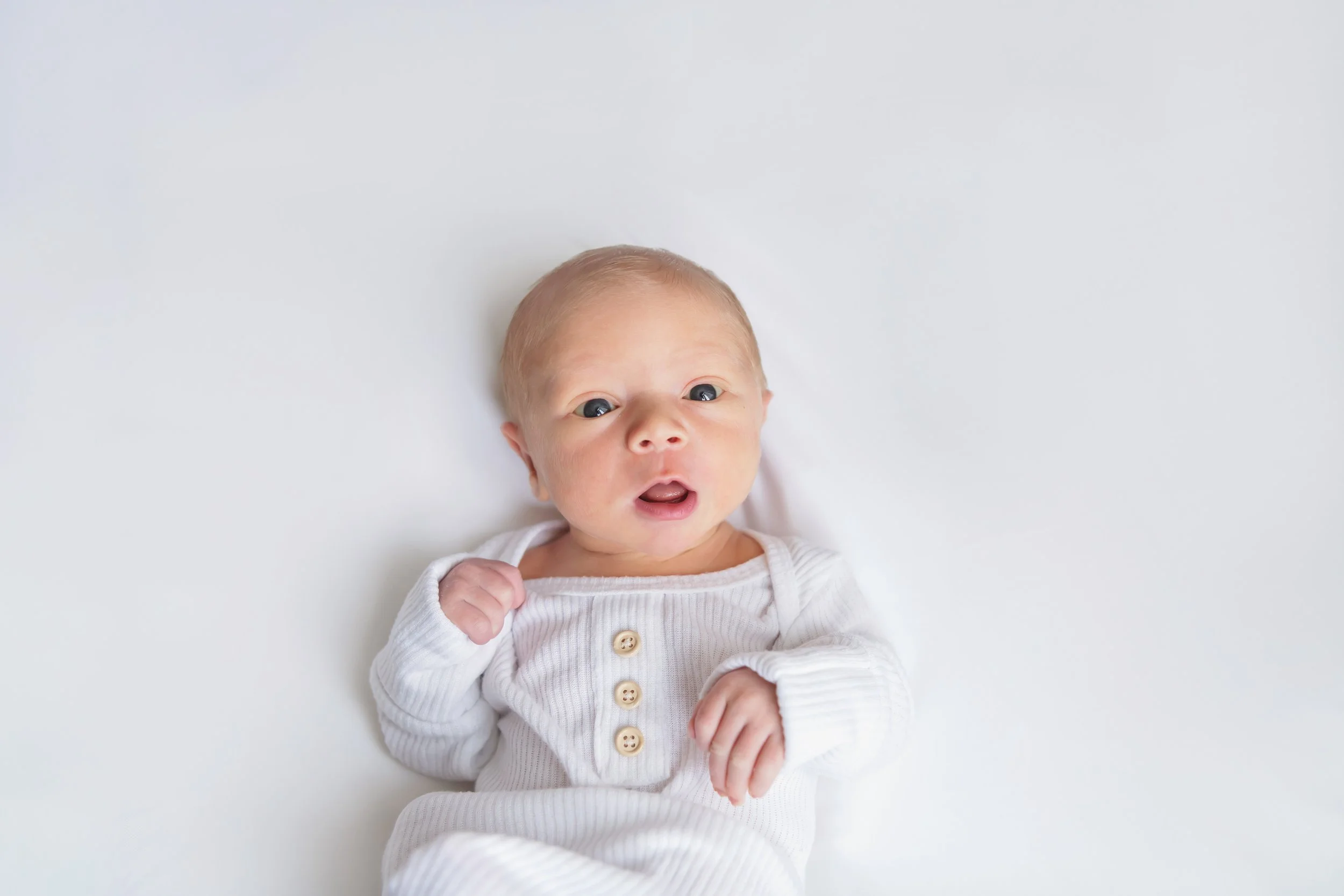 Awake newborn session in a simple white newborn set up 
