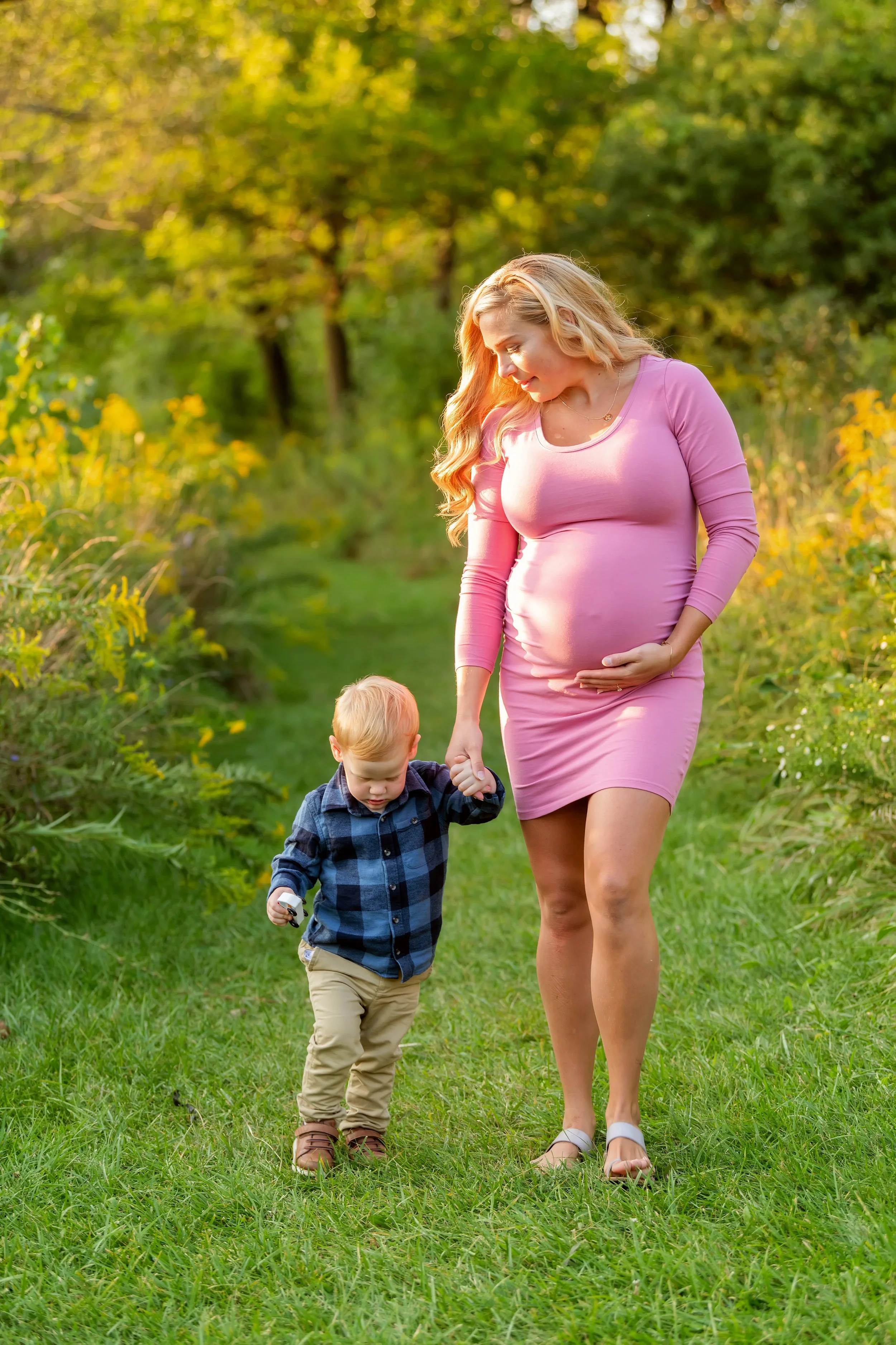 Mom and Toddler walking holding hands in a summer session.jpg
