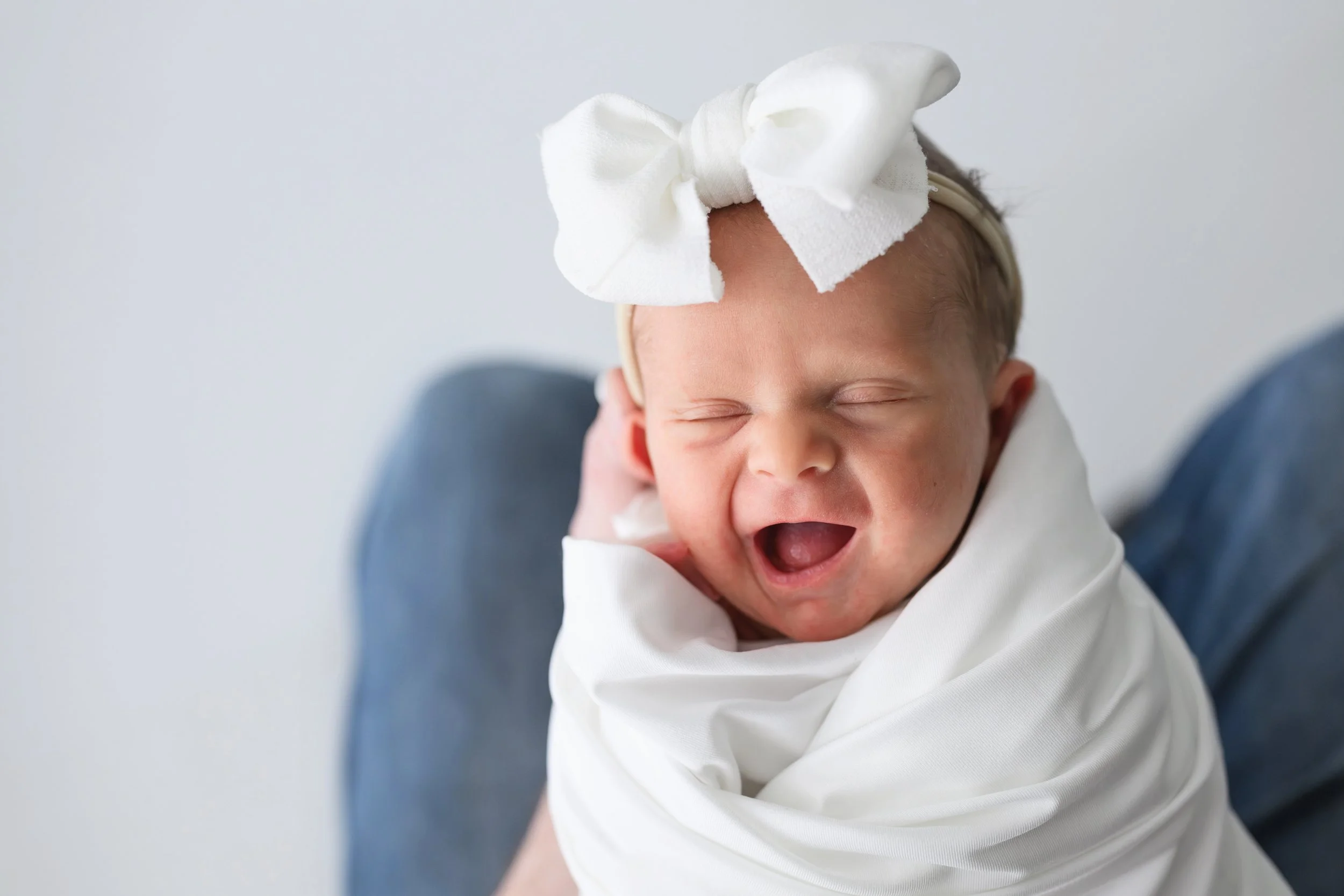 Baby in parents arms during a newborn session 