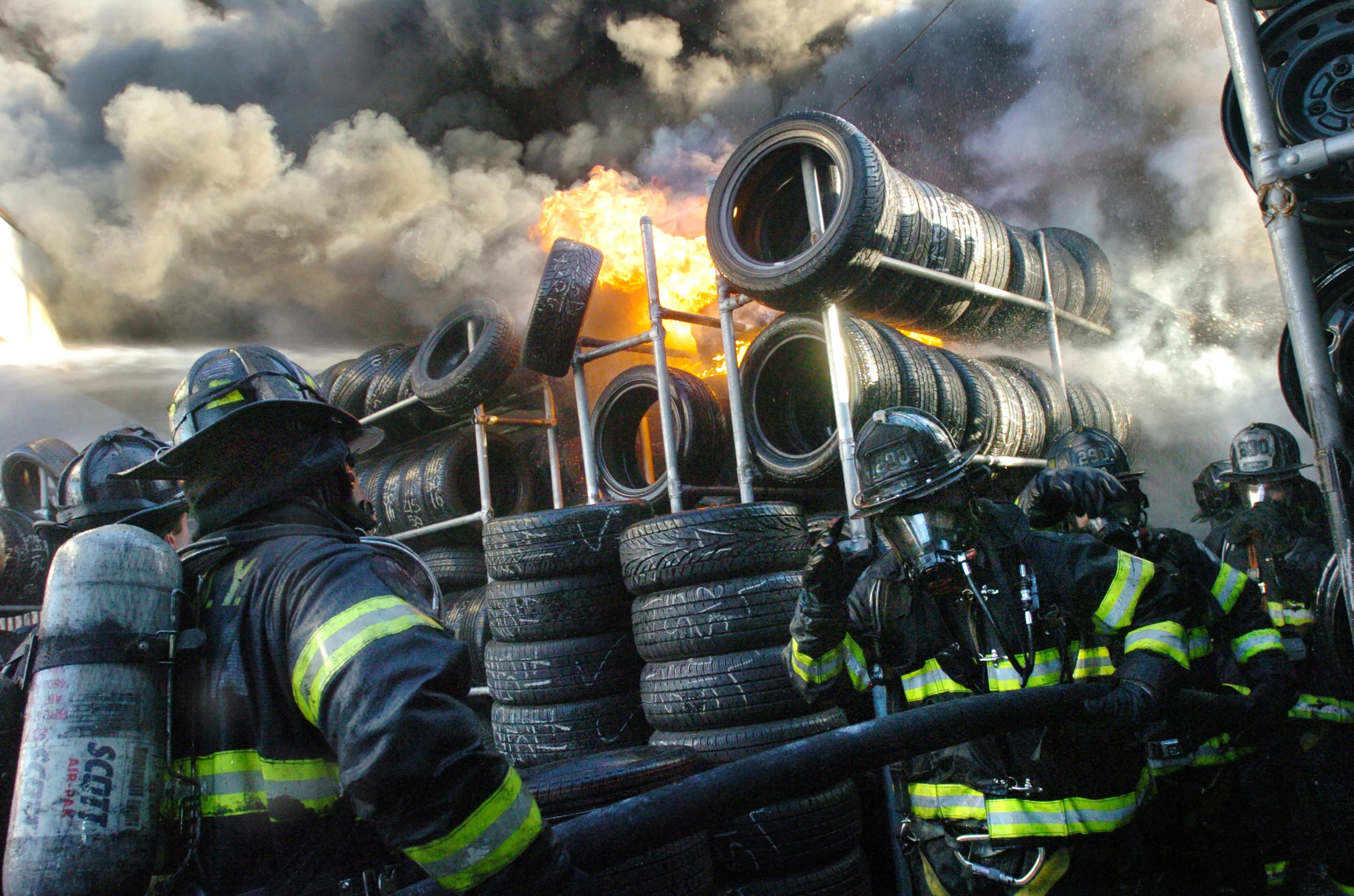  Firefighters donning masks retreat from explosions and heat within a suspicious two-alarm fire ripped through Peter's Custom Tire Shop on Linden Blvd in East New York, Brooklyn December 20, 2006, causing the skies around for miles to turn black from