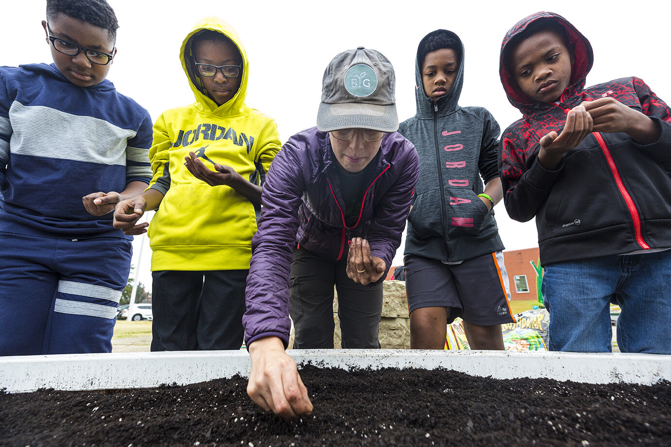 Erika Hansen of Big Green assists Highland Oaks Elementary students (left to right,) Kolin Pratcher, Elijah Smith, Deante Strong, and Xavier Smith in planting in their garden for local Planting Day in Memphis, TN