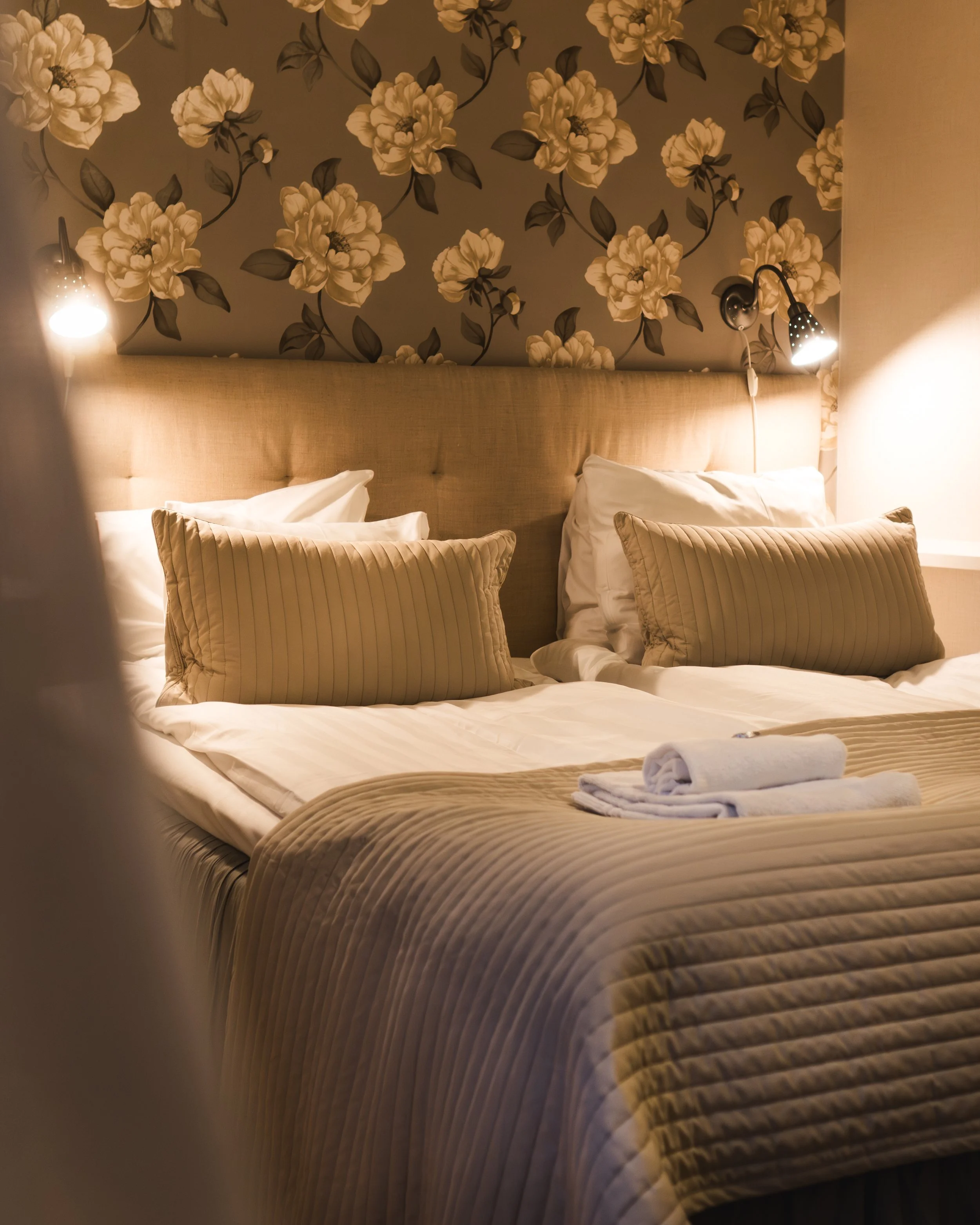 "Hotel room with freshly made bed, soft lighting, and Scandinavian interior design – an inviting and relaxing space for guests looking for an authentic hotel experience in Sweden."
