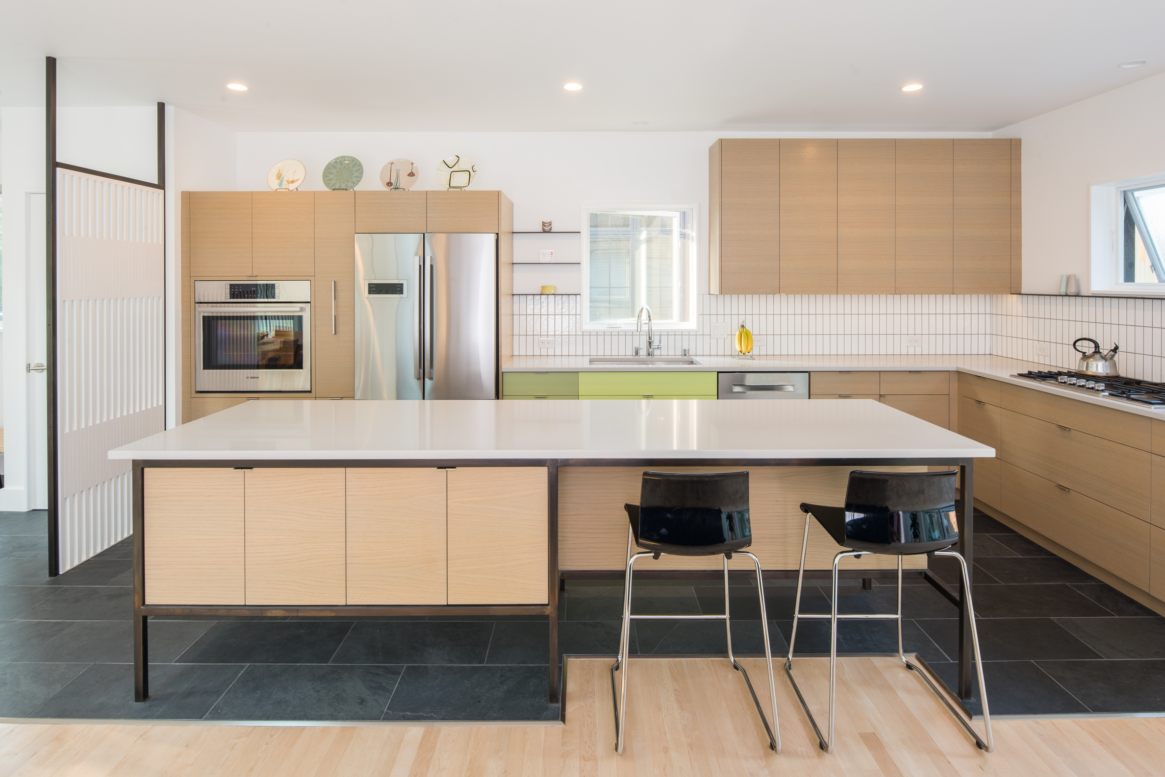 Custom mid-century kitchen design with colorful cabinetry and steel accents